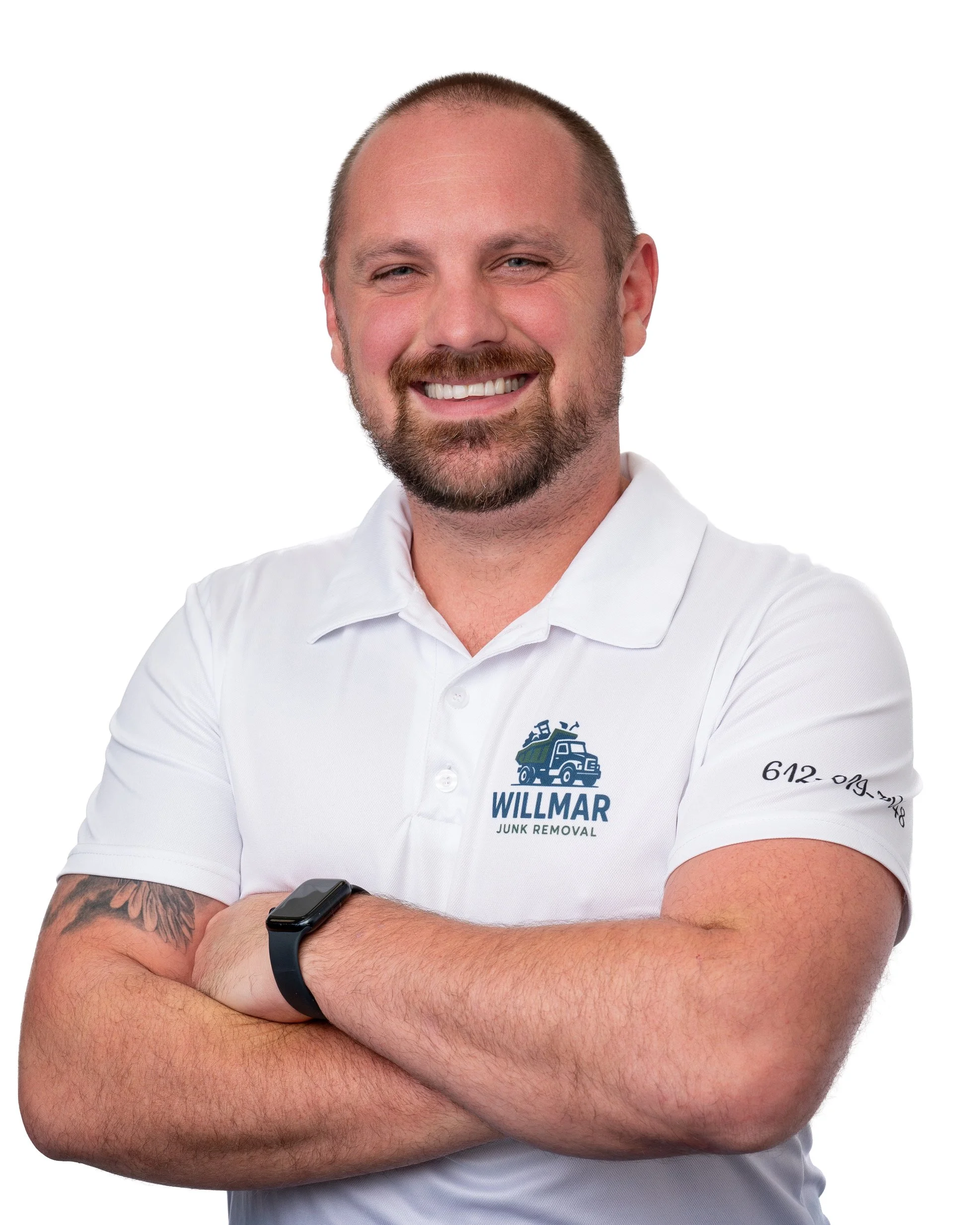 A smiling man with a beard and short hair wearing a white polo shirt with a "WILLMAR JUNK REMOVAL" logo, crossing his arms, against a plain white background.