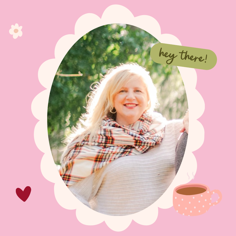 A smiling woman with blonde hair wearing a cream sweater and a plaid scarf, outdoors with green foliage in the background. The image is framed with a pink and white scalloped border, and has a speech bubble saying 'hey there!', a red heart, and a pink polka-dotted coffee mug.