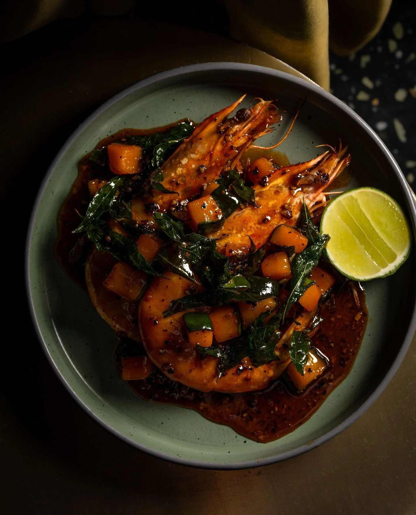 Black Pepper Prawns with red kuri squash and curry leaves. A nod to Singapore&rsquo;s iconic black pepper sauce, where slow-building heat meets a touch of sweetness.