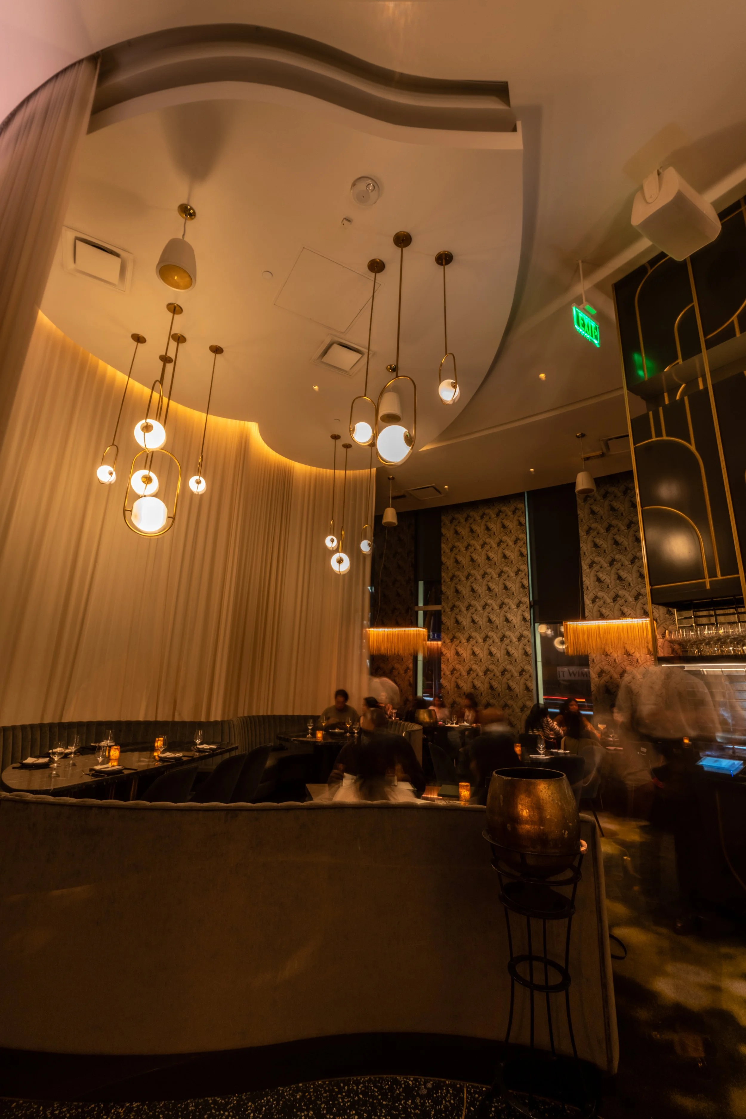 Heart private event space during evening service, featuring dramatic pendant lighting, curved ceilings, and intimate booth seating, downtown San Diego