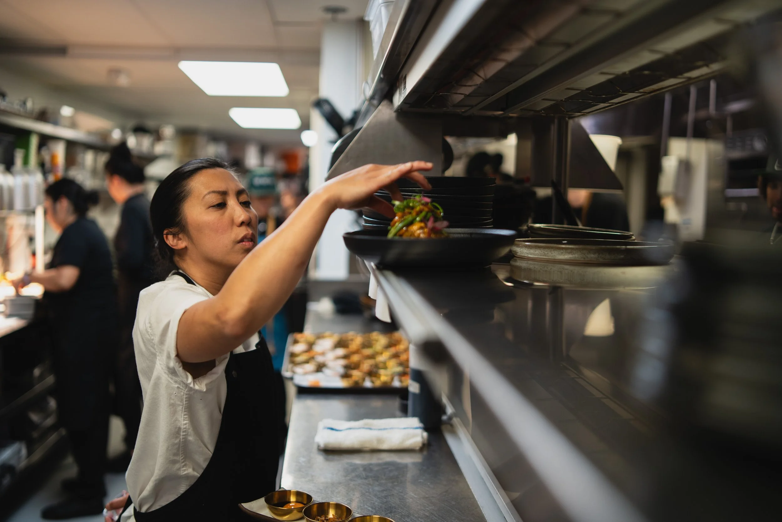 Executive Chef Tara Monsod plating dishes on the pass in the Animae kitchen, San Diego