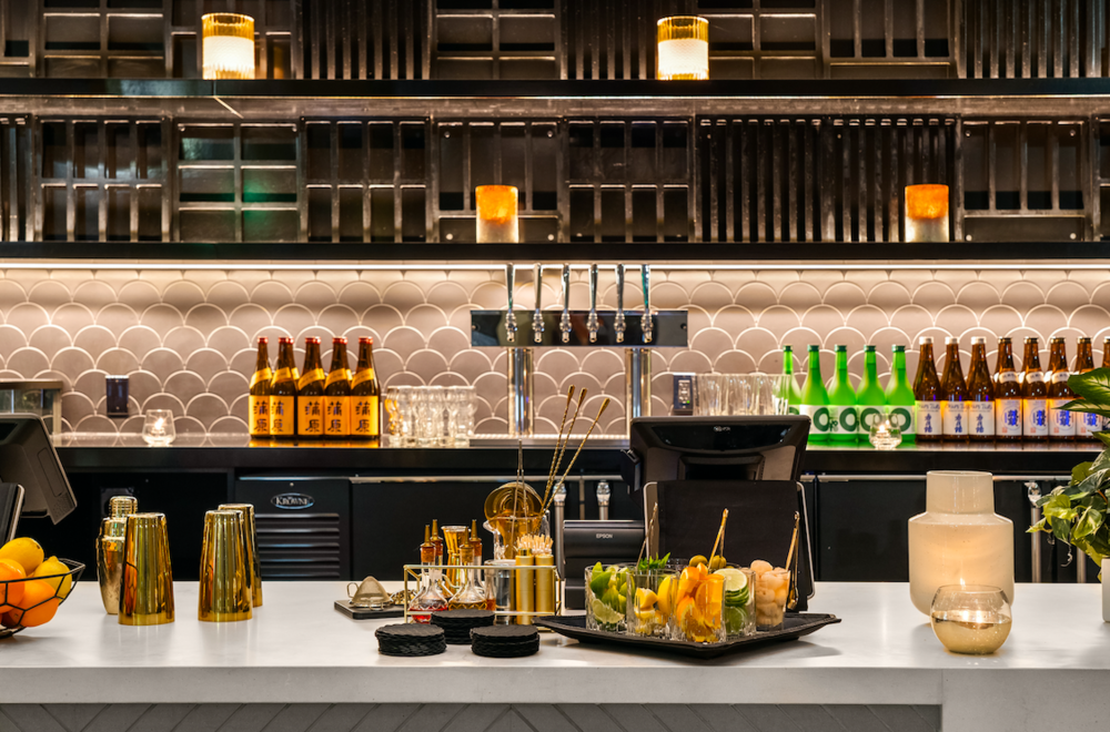 Nima bar setup featuring Japanese sake, beer, cocktail tools, and fish-scale tile backsplash, downtown San Diego