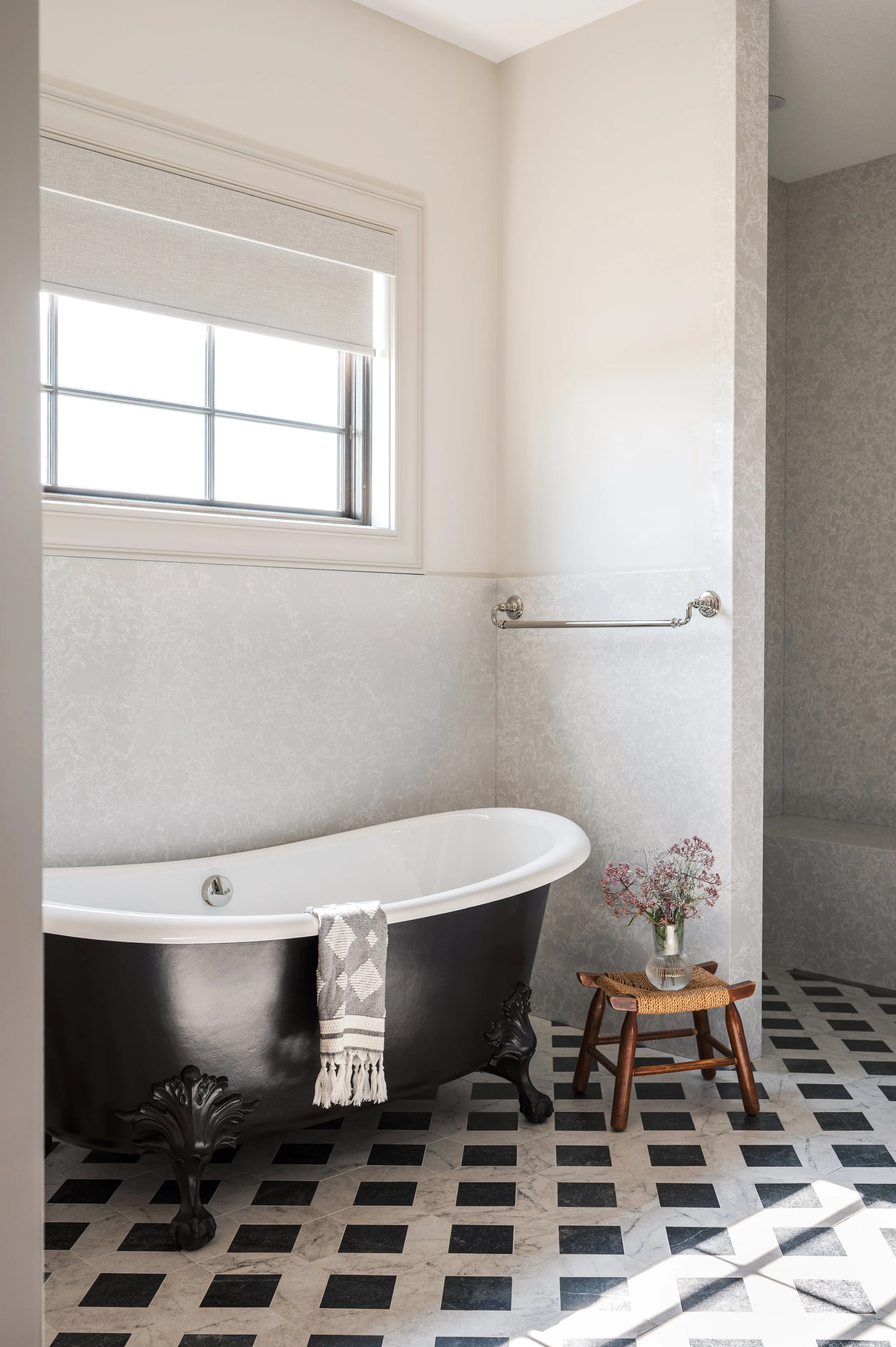 Custom primary bathroom by Texturious Designs featuring a black freestanding tub, patterned tile flooring, and a walk-in quartz shower.