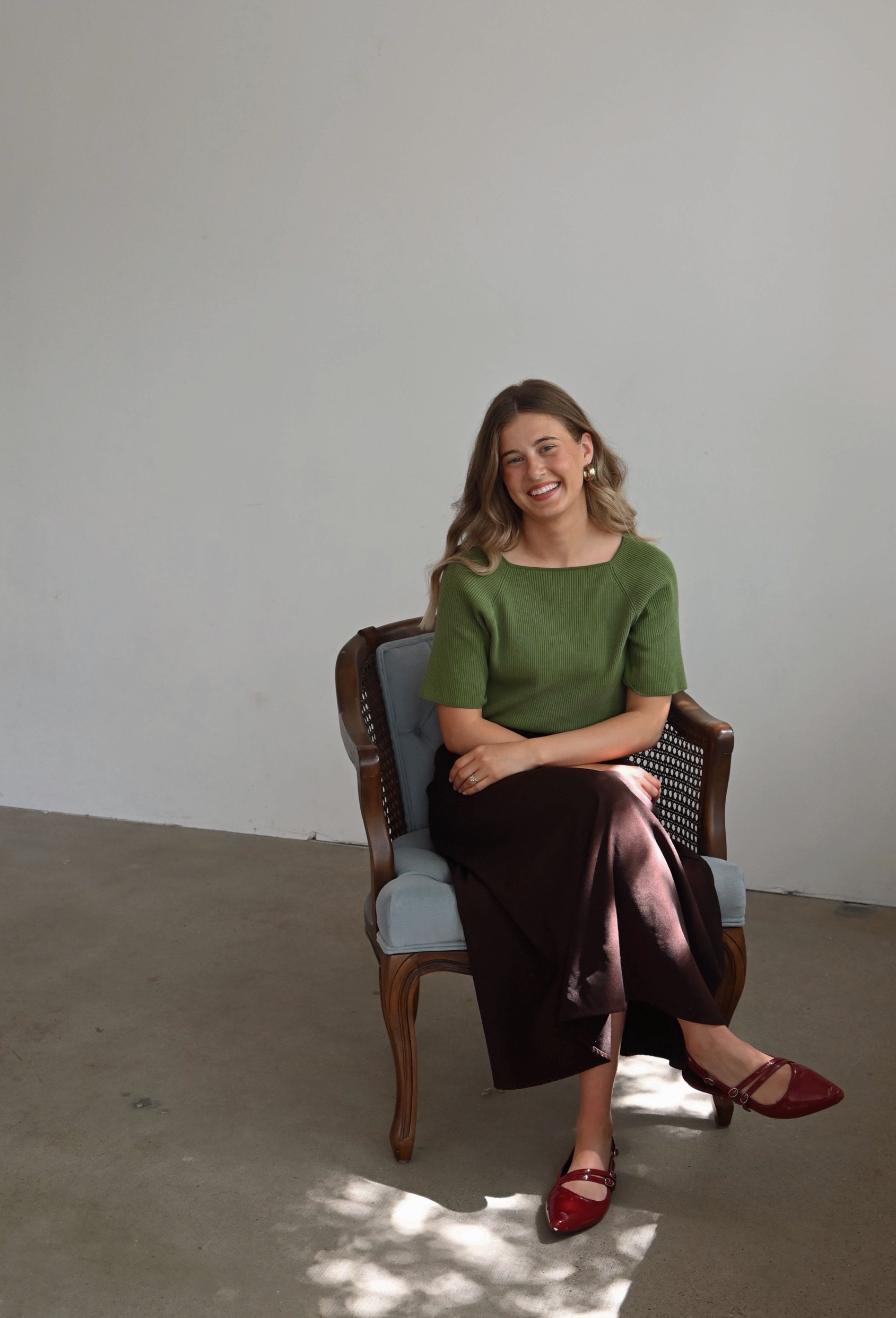 Kayla VanHorn, lead interior designer at Texturious Designs in Des Moines, Iowa, seated in a studio portrait.