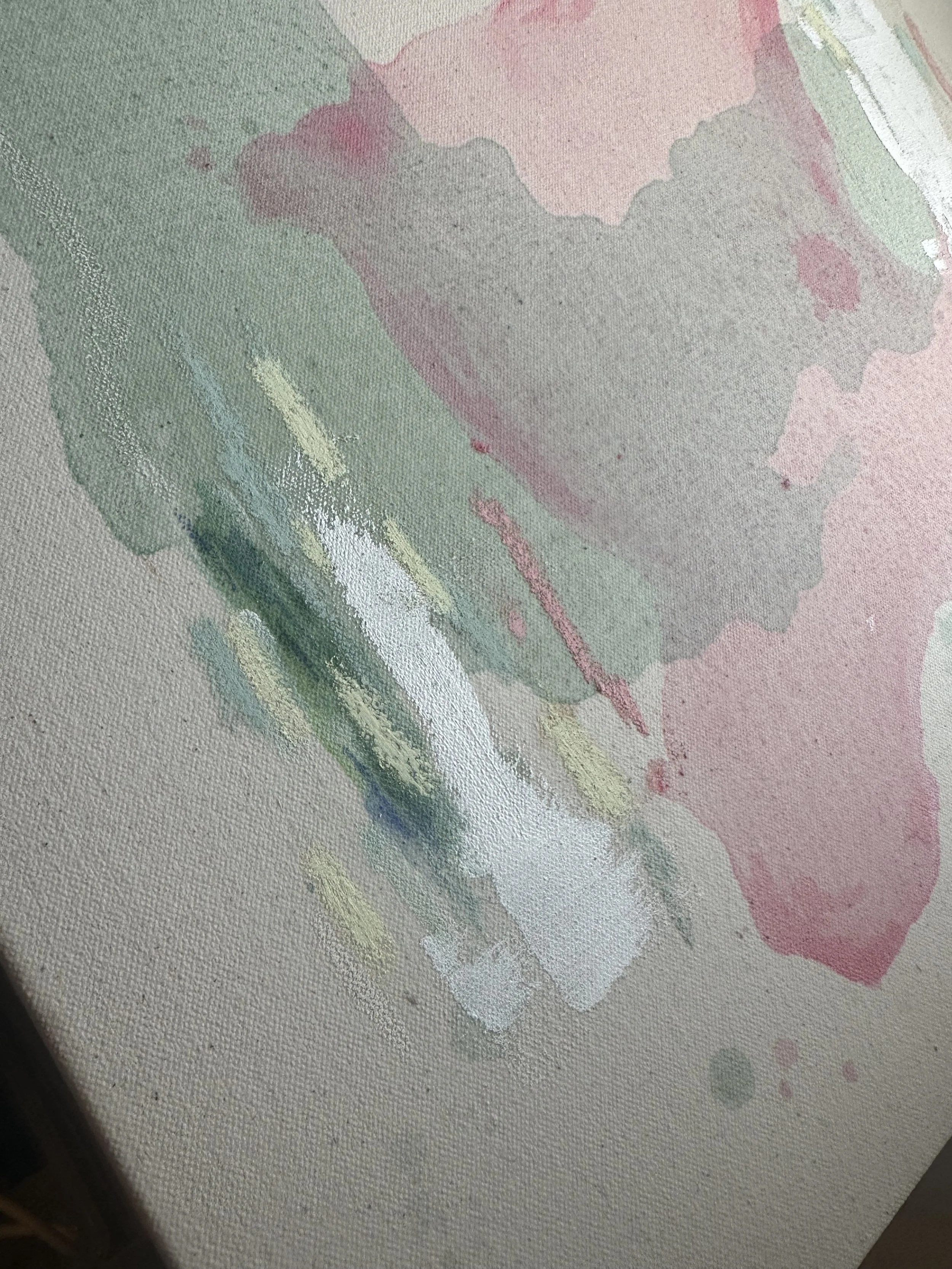 Close-up of a watercolor painting on canvas with soft pastel colors, including pink, green, purple, and hints of white, with visible textured brushstrokes.