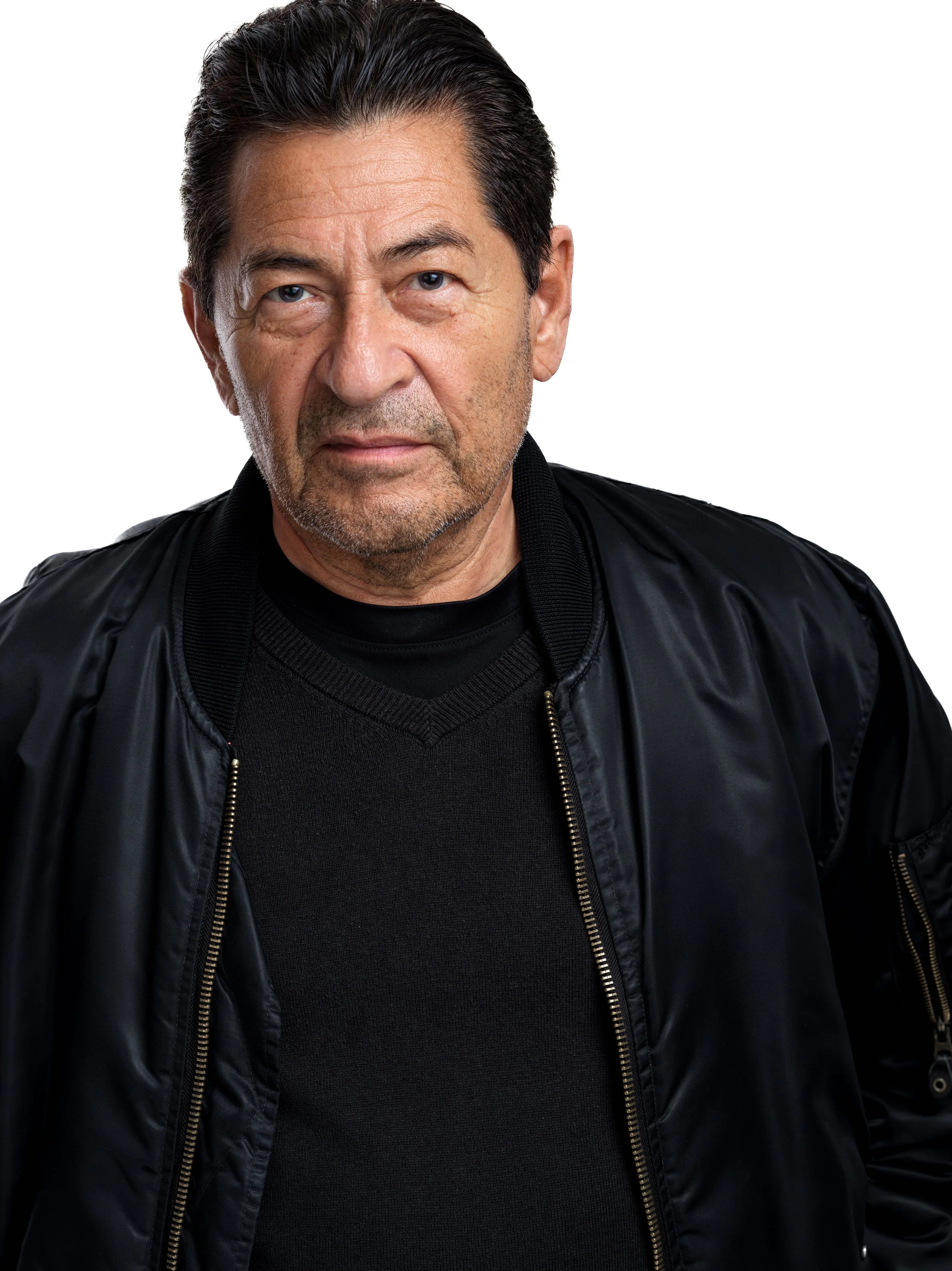 Close-up portrait of a middle-aged man with dark hair, wearing a black leather jacket, against a plain white background.