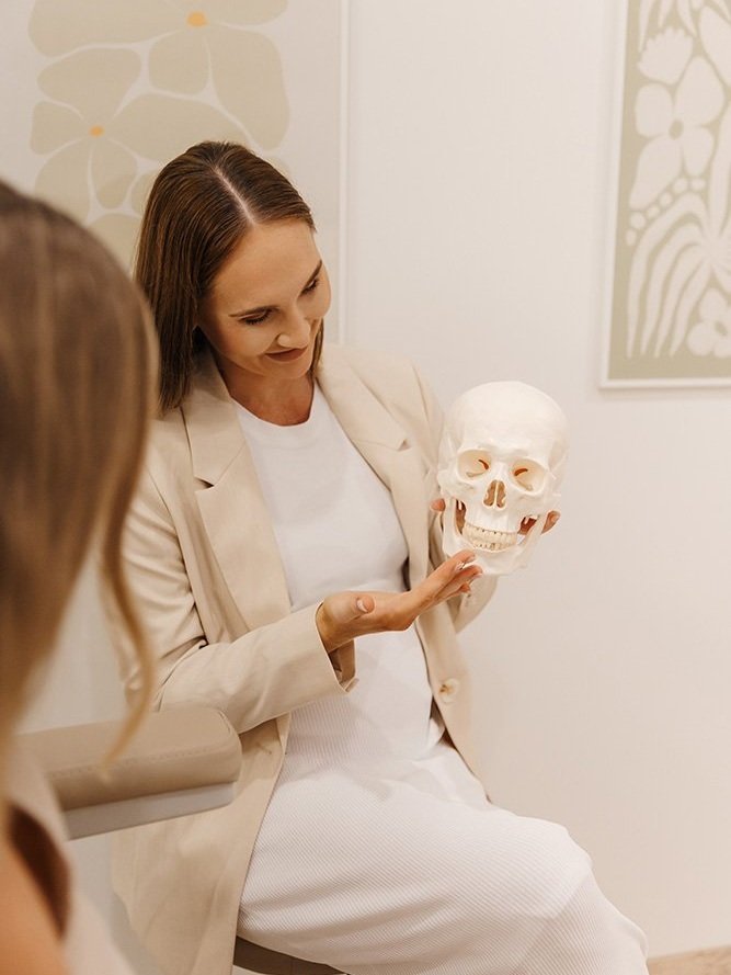 A women sits holding a human skull