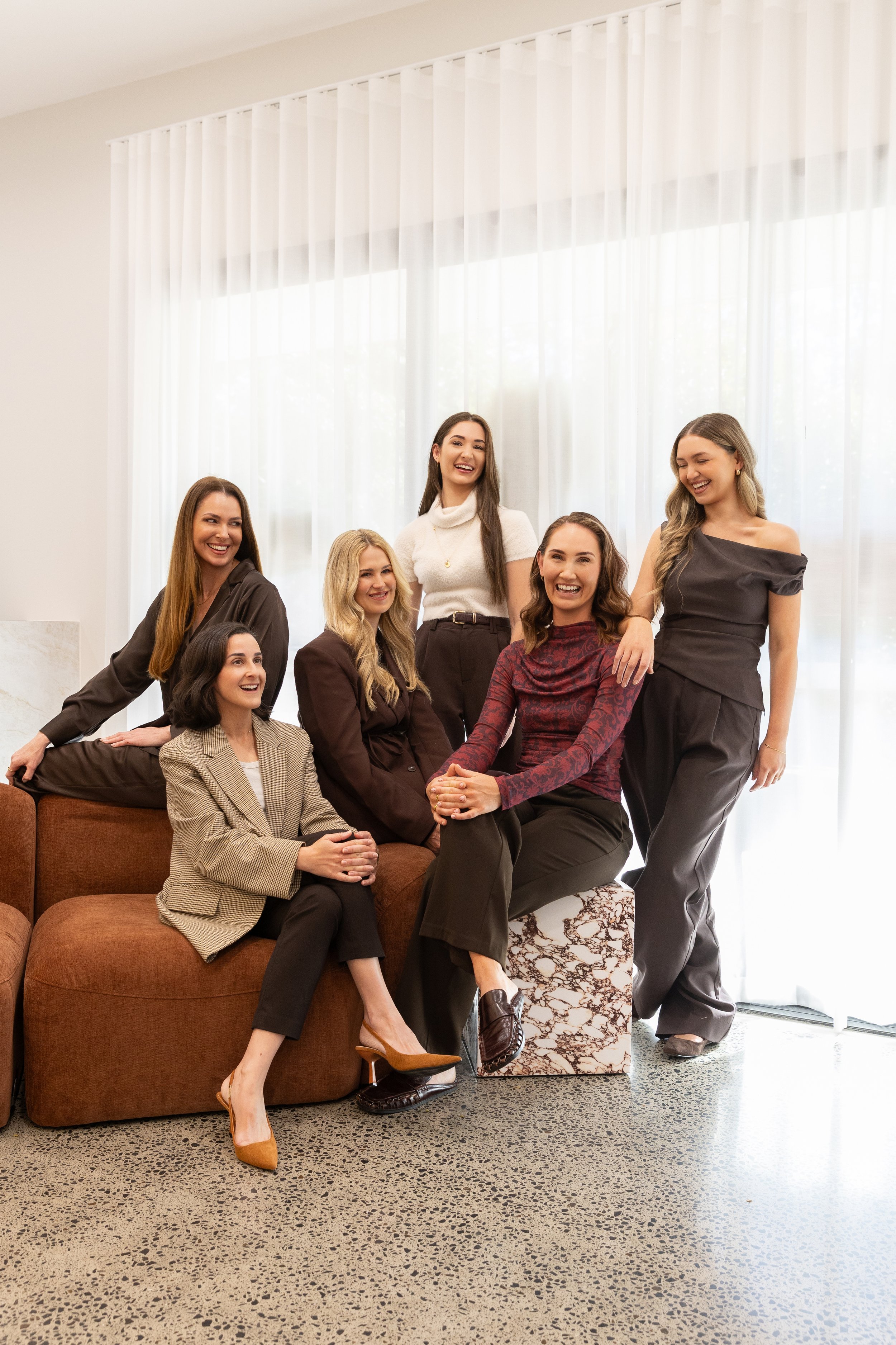 a group of women stand together smiling at each other