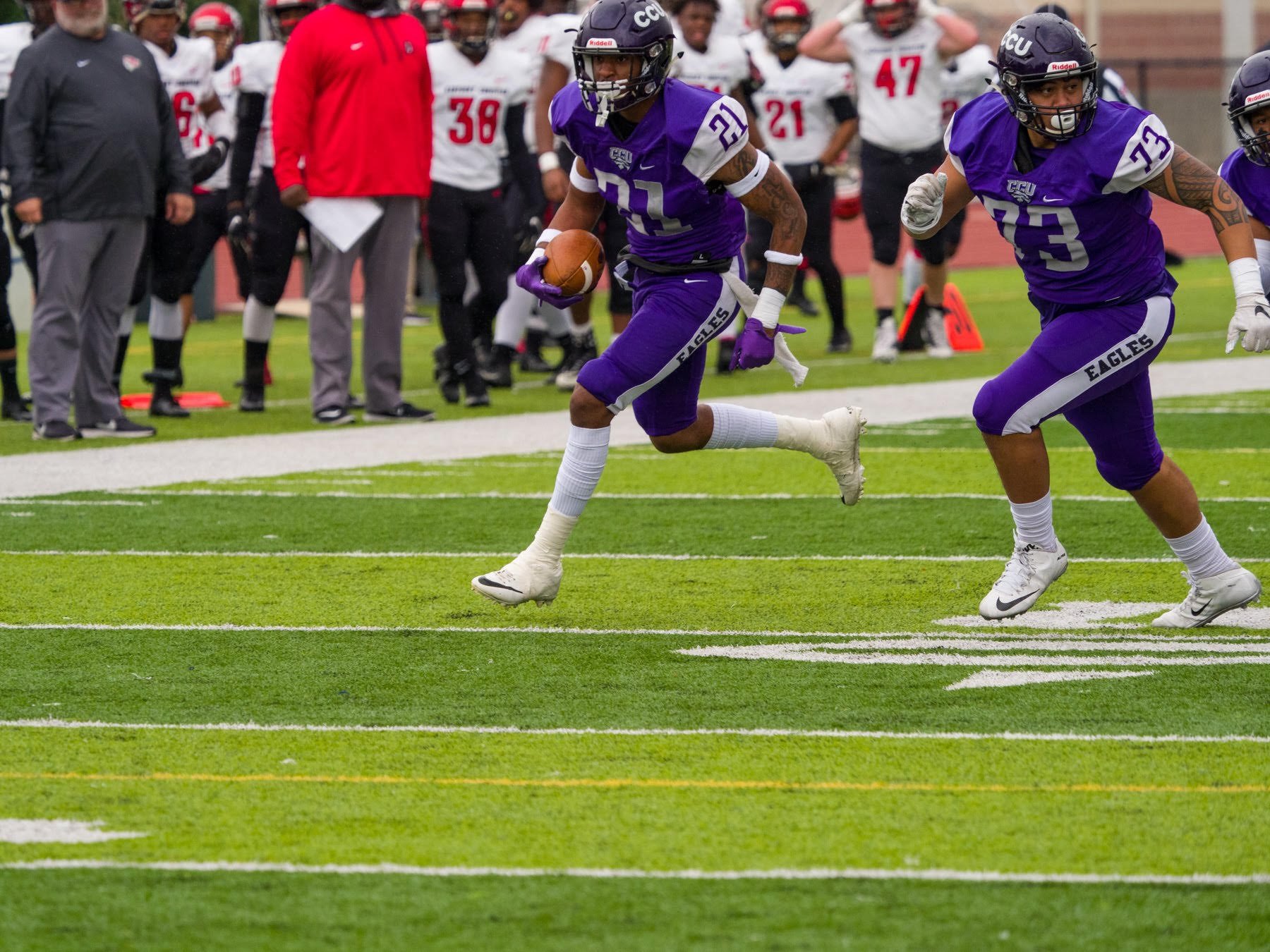 CEO DeQuan Render #21 running with the ball  - representing the constant transition of being an athlete.