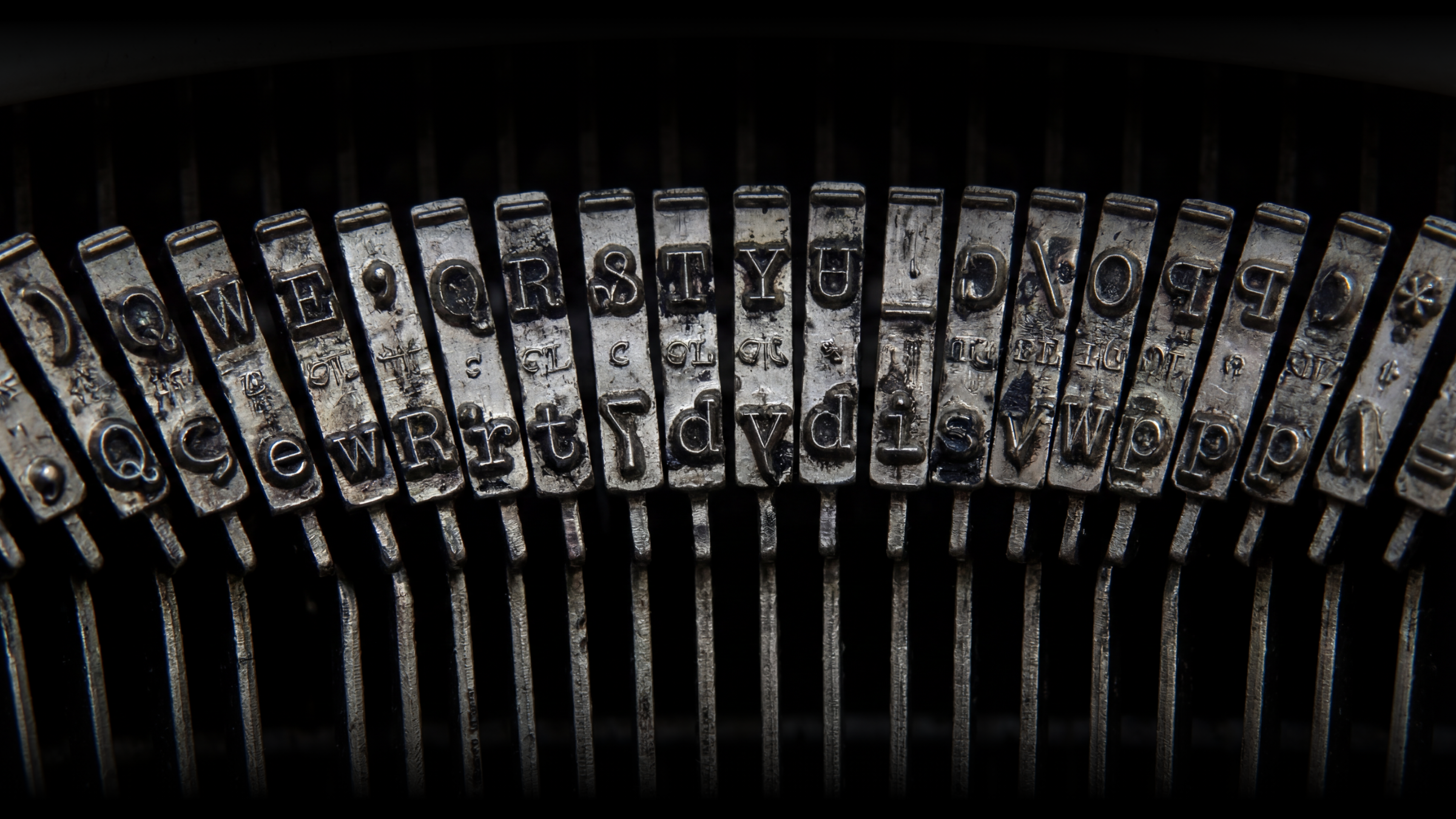 Close-up of the keys on an old typewriter, showing letters and symbols on metal key sticks.
