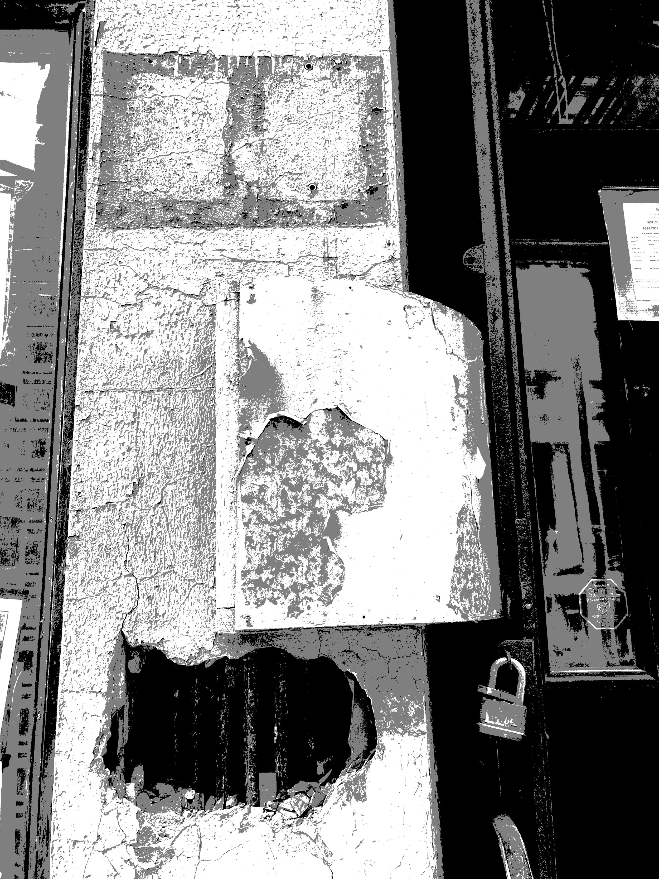 Close-up of a damaged wall with peeling paint, cracks, and a partially broken section revealing the internal structure.
