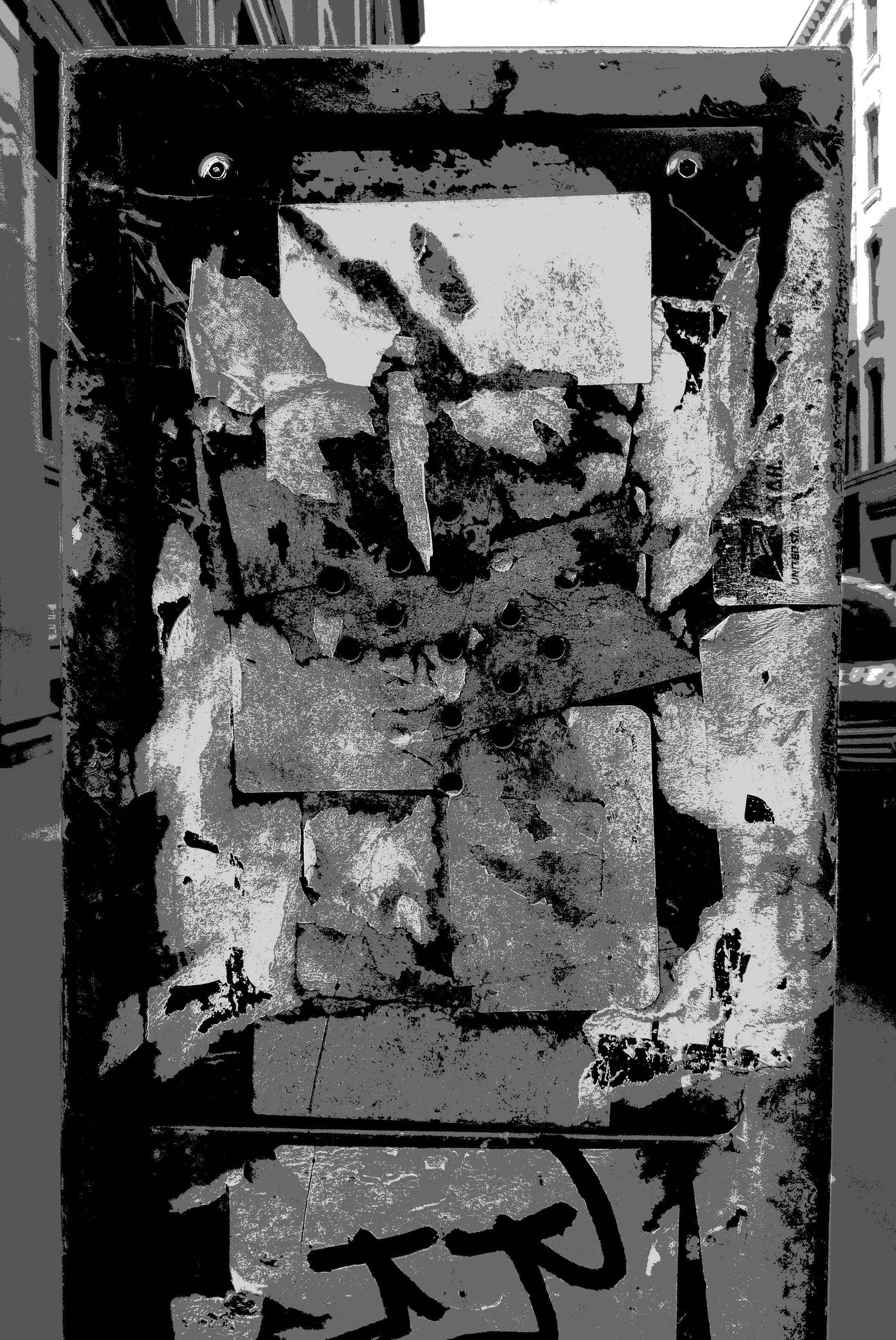 A rusted and damaged metal electric heater or oven with peeling paint and graffiti on the front panel, positioned in a corridor with bookshelves on either side.