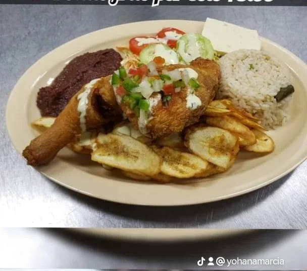 Plate of Mexican food including grilled chicken with salsa, rice, plantains, a fried chicken drumstick, refried beans, and a side salad with cucumbers, tomatoes, and lettuce.