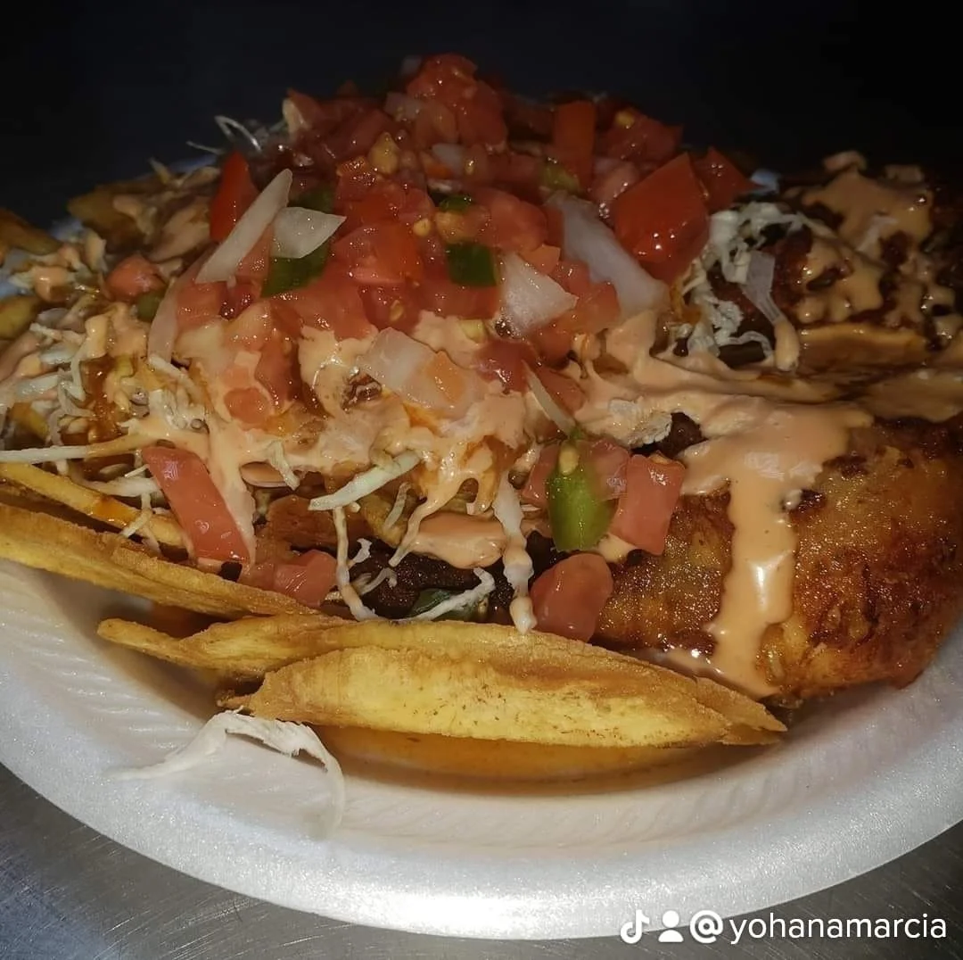 Taco topped with diced tomatoes, onions, and jalapeños on a bed of fritos chips.