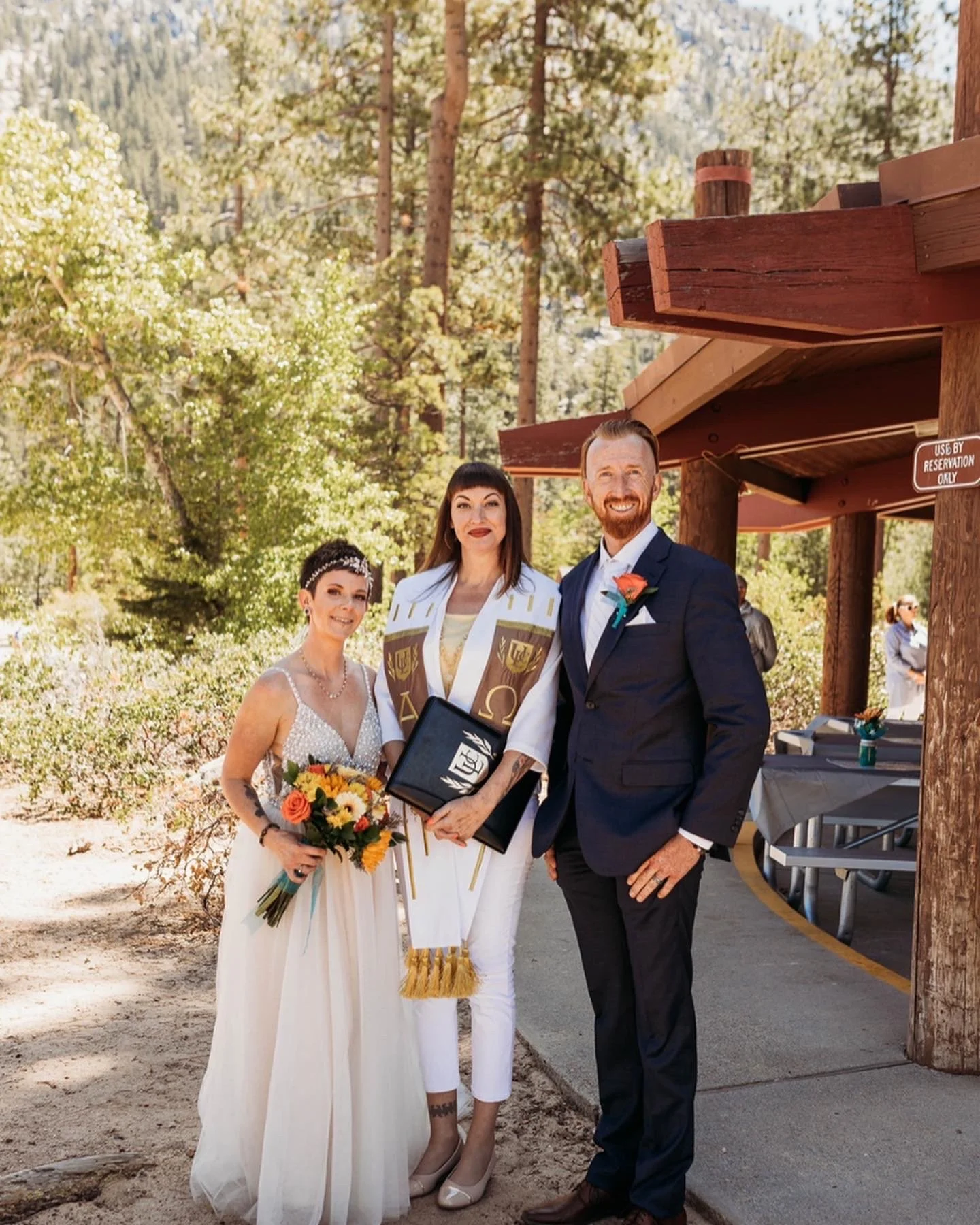 A wedding ceremony outdoors at Sand Harbor with bride, groom and officiant.