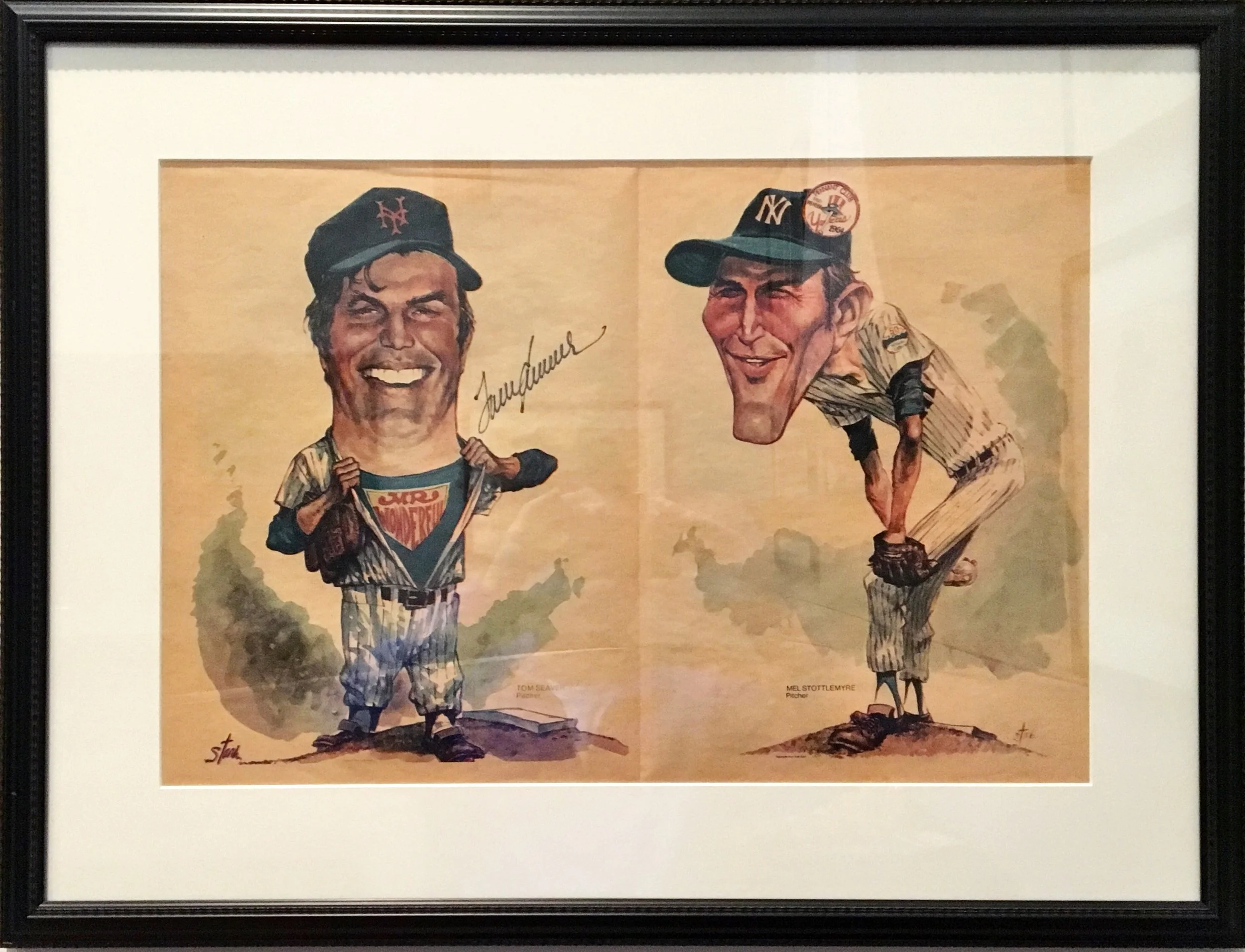 Framed illustration of two caricatured baseball players smiling and posing. The player on the left wears a New York Mets cap and is lifting his shirt to reveal a superhero costume with the words "Super Sluggers". The player on the right wears a New York Yankees cap and has his hand on his cheek, wearing a striped shirt and standing with one foot on a rock. The illustration signatures are at the bottom.