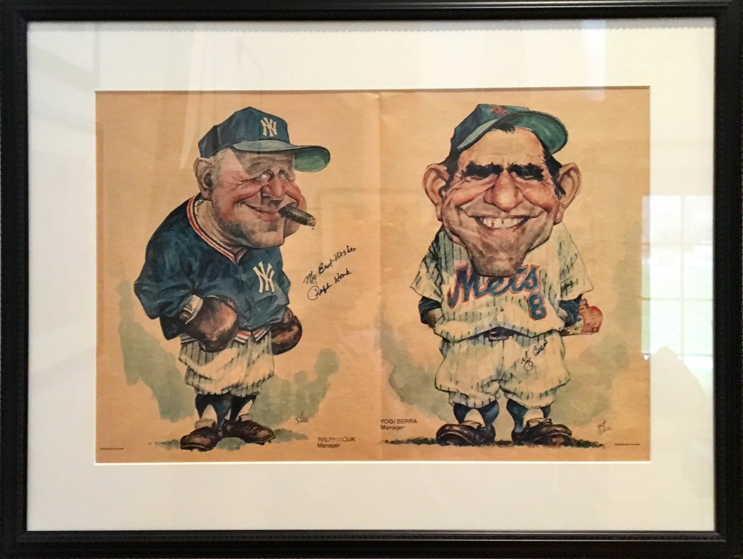 Framed caricature illustration of two baseball managers, Ralph Houk on the left and Yogi Berra on the right, both wearing New York Yankees uniforms and caps, with signatures and signatures of their names and titles below.