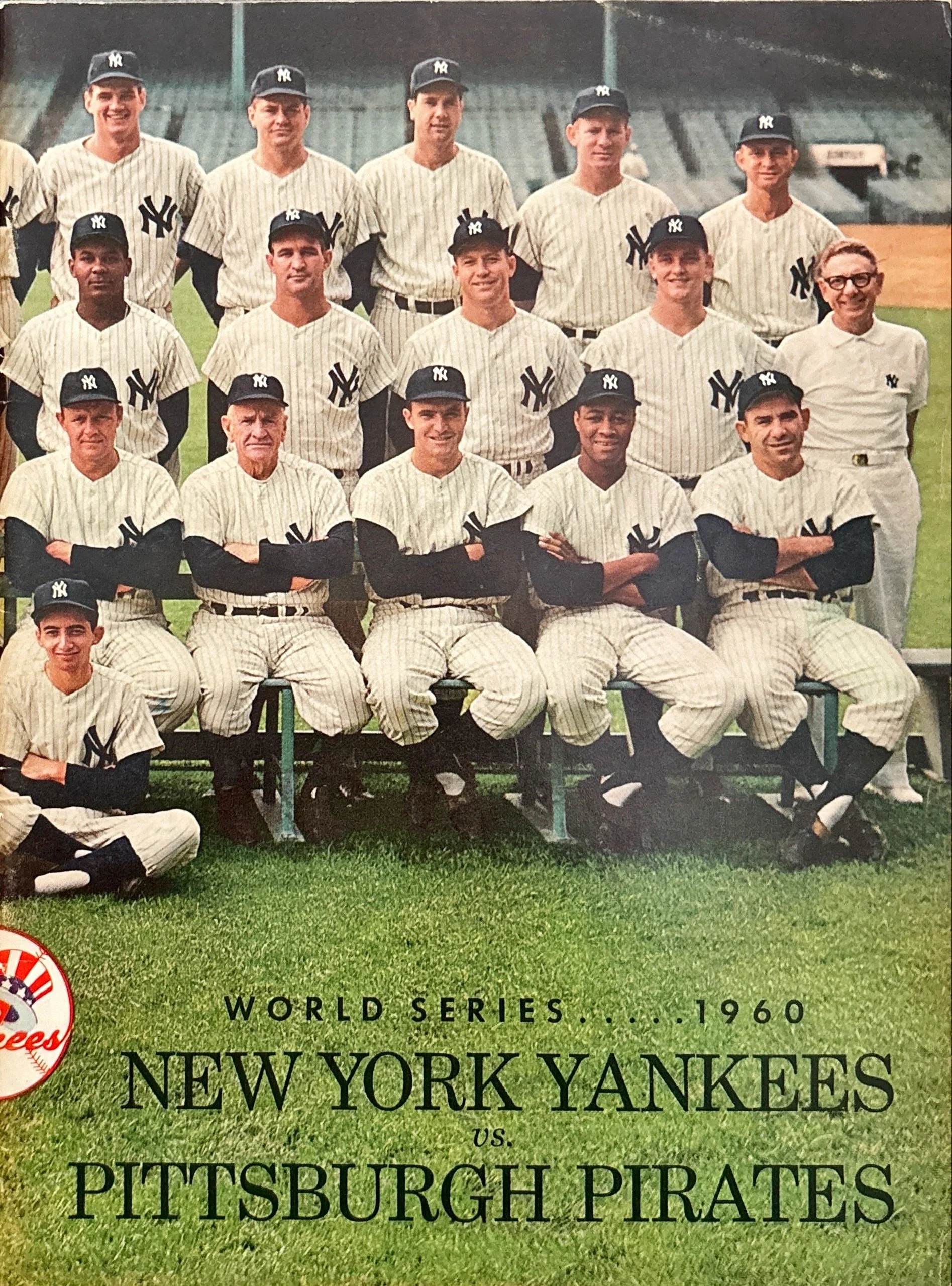 Black-and-white photograph of a New York Yankees baseball team from the 1960 World Series, taking a team photo on a baseball field with empty stands in the background.