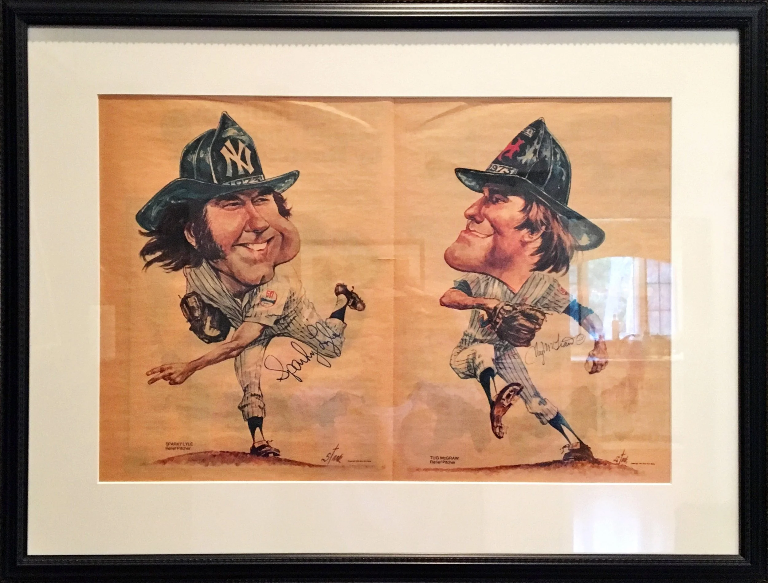 A framed caricature illustration of two relief pitchers, Sparky Cycle and Tug McGraw, animated with exaggerated facial features and expressions, wearing baseball uniforms and hats. The illustration style is whimsical and cartoonish.