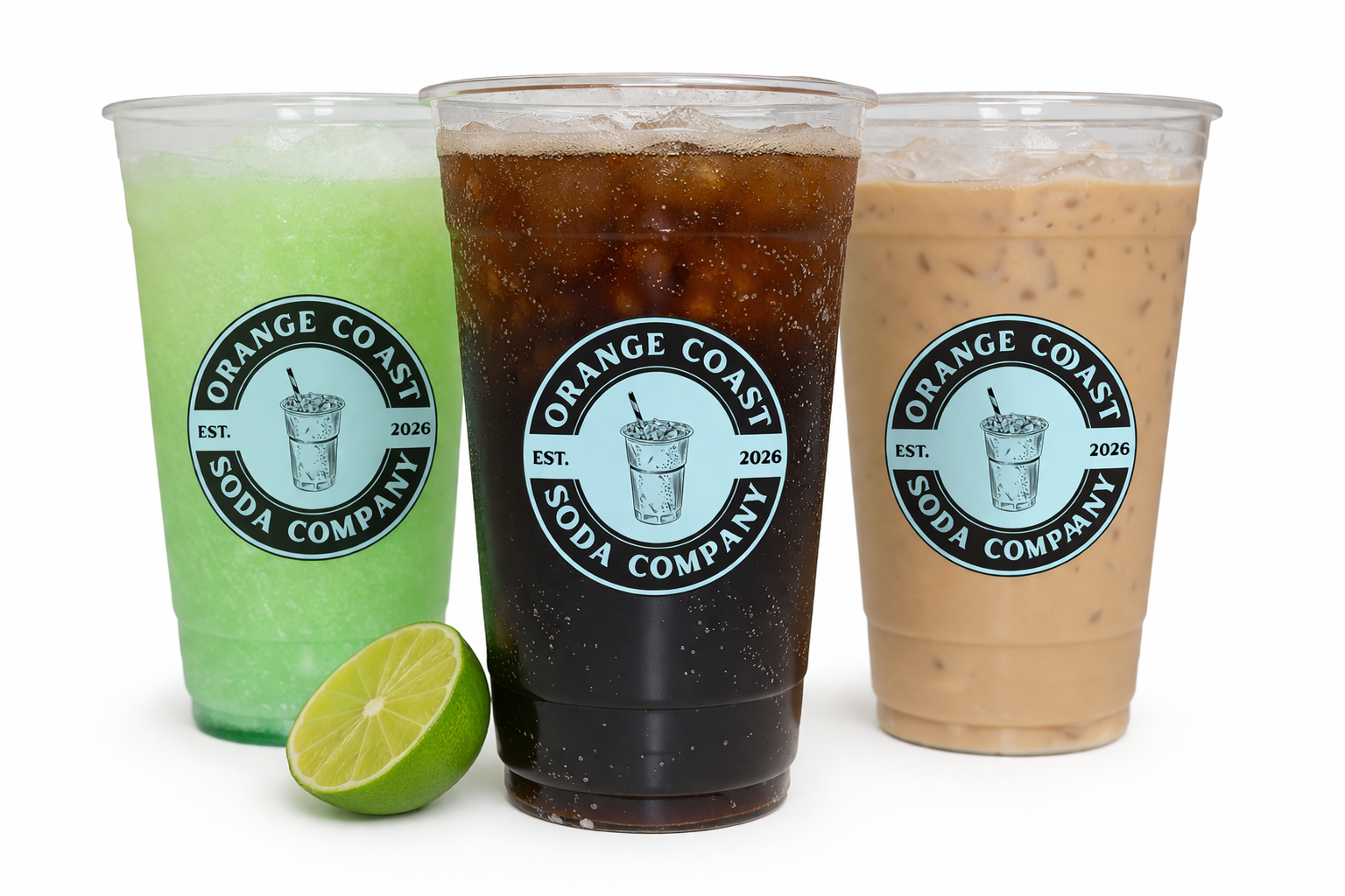 Three plastic cups of soda with orange coast soda company labels, one green lime, one dark cola, and one cream-colored iced beverage, all on a white background.