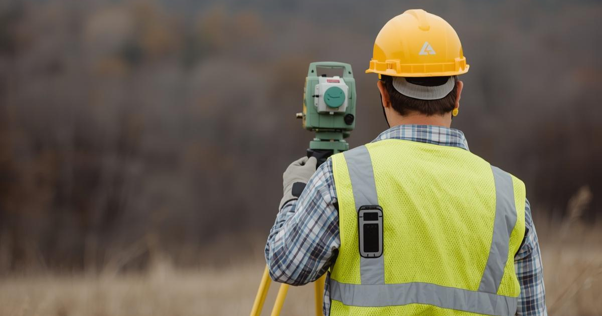 Survey crew using field equipment for professional land surveying services.