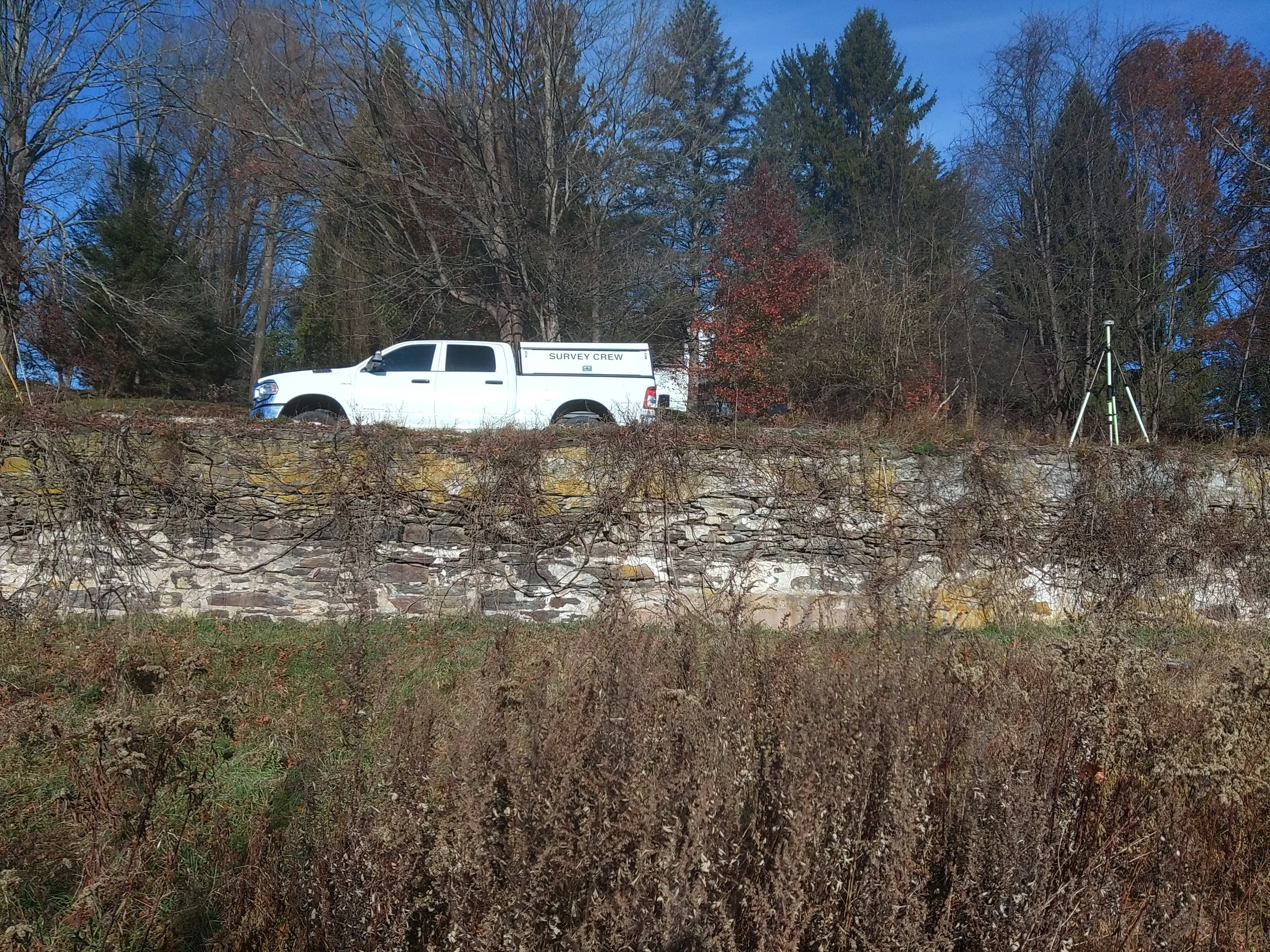 Survey crew equipment positioned in a wooded area for property line evaluation.