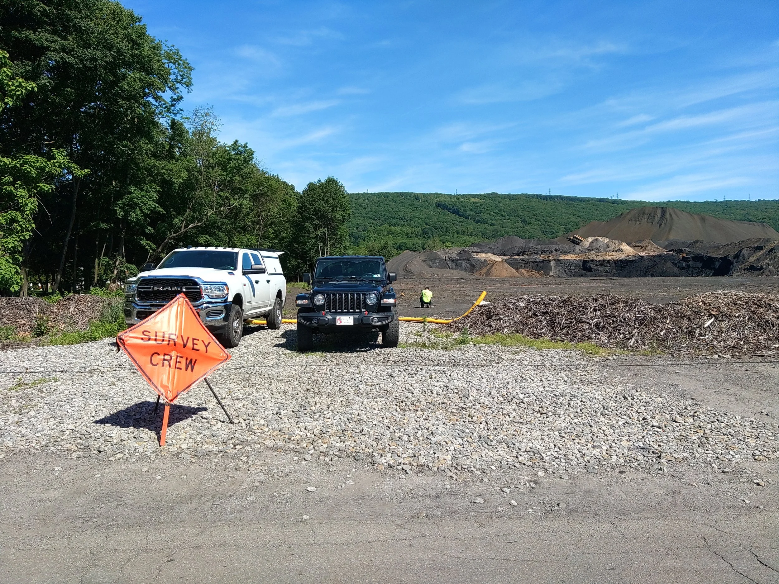 Survey crew vehicle and field signage at an active work site during pre-construction layout preparation.