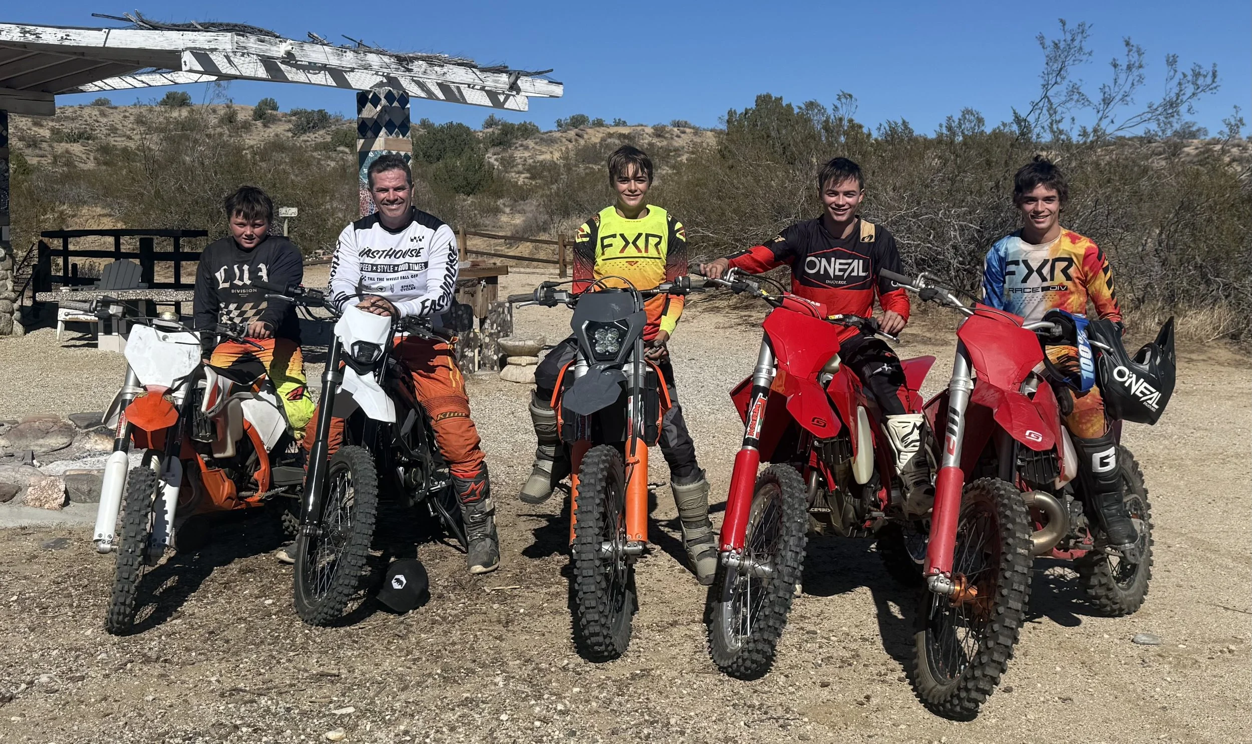 Five boys standing with dirt bikes enjoying Southern California desert racing and family.  An active family needs a living trust, medical release forms, helicopter insurance in case something happens.