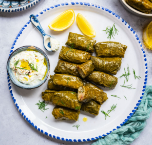 Dolmathes - Delicate grape leaves stuffed with seasoned ground beef, rice, and classic Greek herbs and spices. (GF)