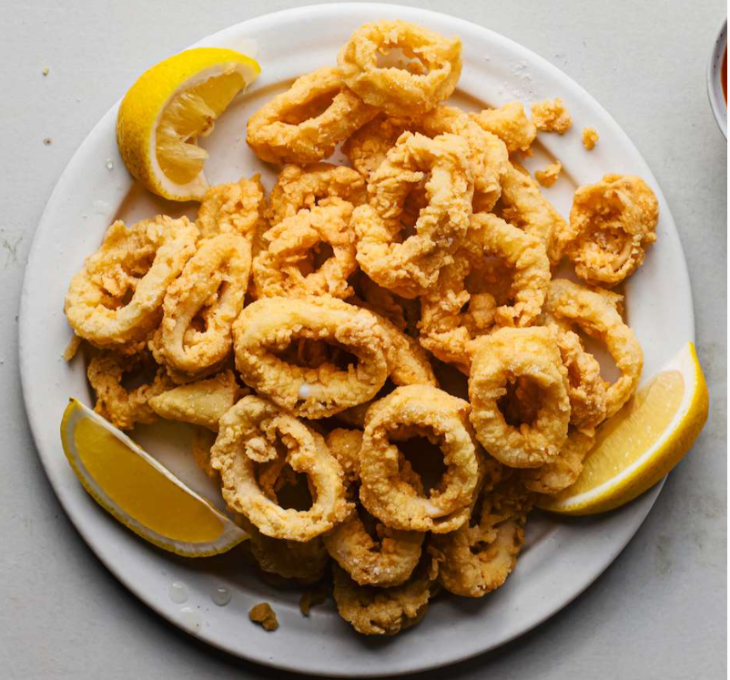 Calamari - Tender squid lightly battered, fried to a golden crisp, and served with a fresh lemon wedge.