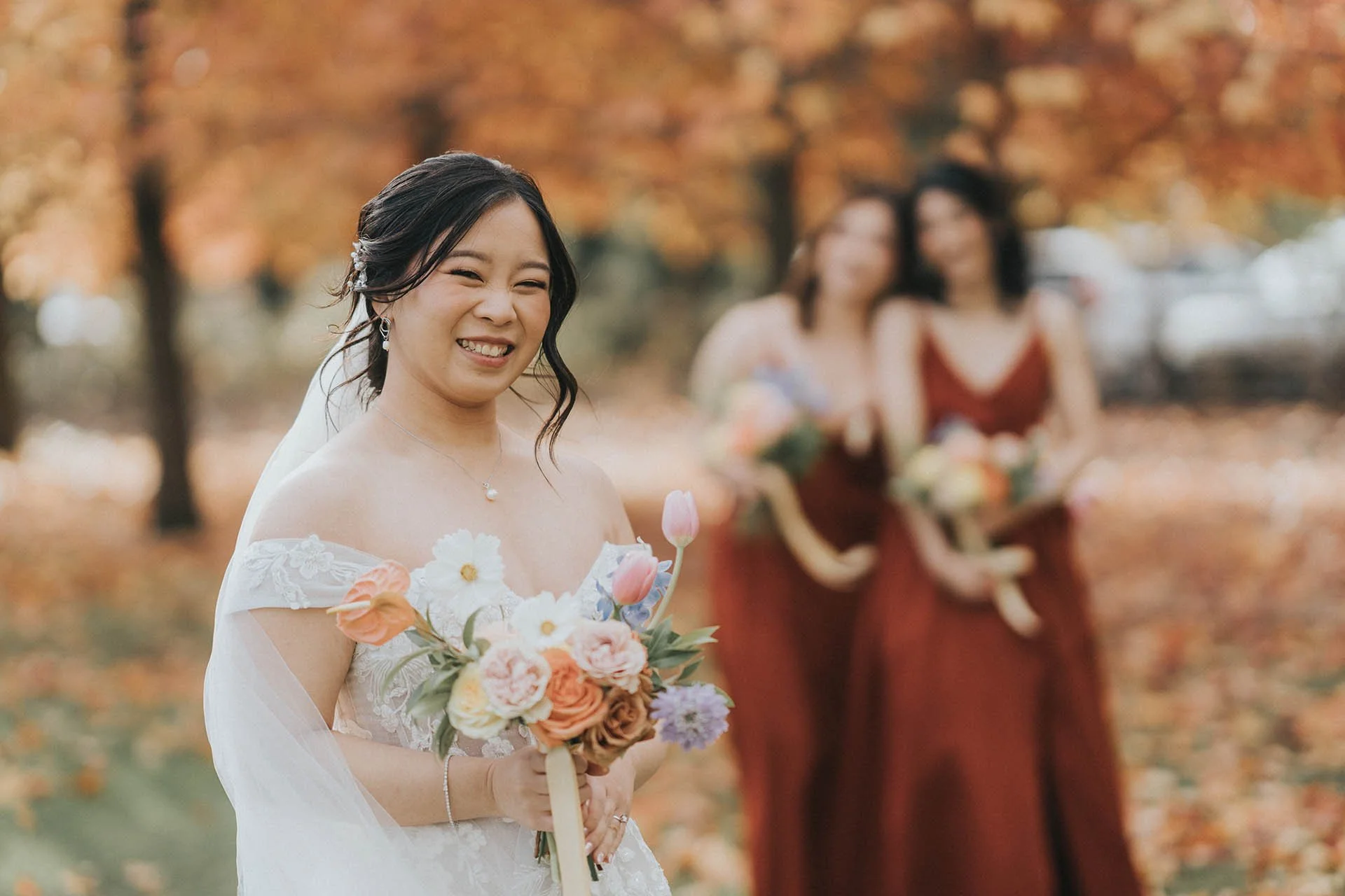 Bride smiling with bridesmaids in rust dresses at Immerse Yarra Valley wedding