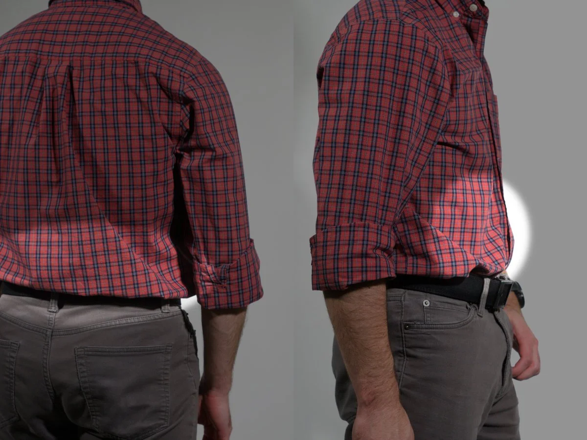 A man wearing a red plaid shirt and gray pants, seen from the back and side, with spotlights showing locations where the shirt is loose.
