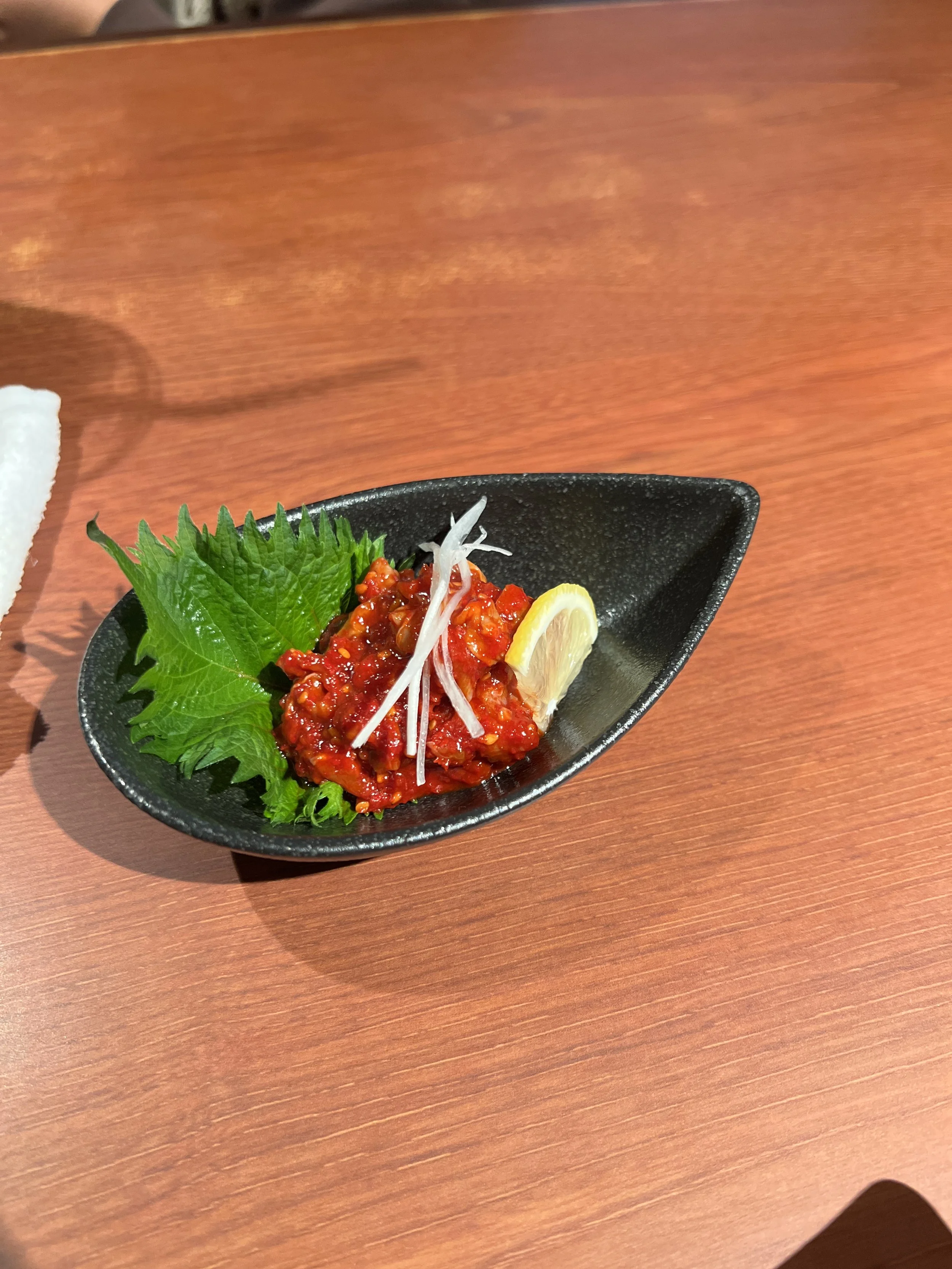 レモンとサラダ菜と一緒に盛り付けられた辛味のある料理