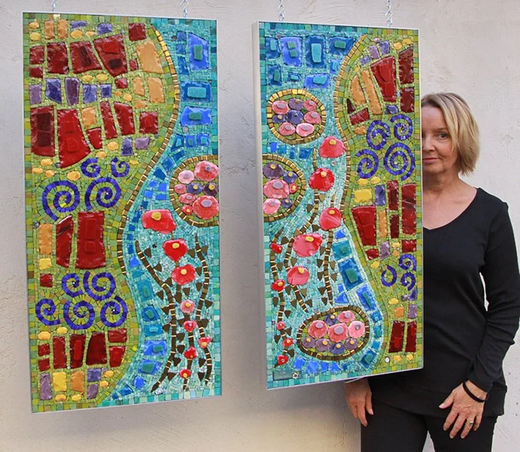 Two mosaic art panels featuring colorful, abstract floral and geometric patterns, with a woman standing beside them.