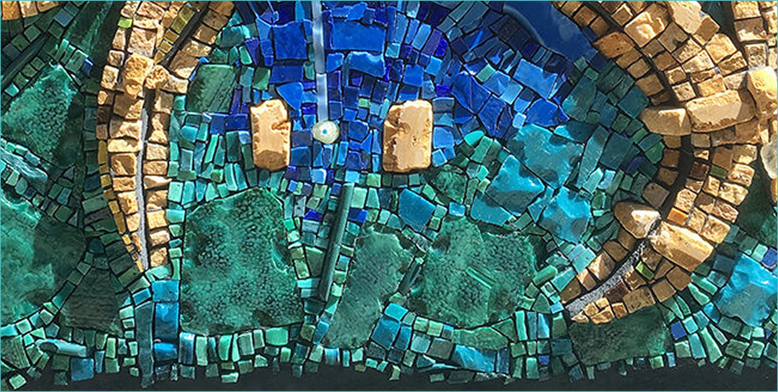 Colorful mosaic art featuring a large blue butterfly with green and yellow accents, created with small tiles and stones.