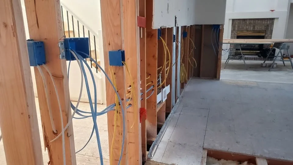 Kitchen remodel rough-in in Westminster — Electrical work during a full kitchen remodel in Westminster, beginning with a 200-amp service upgrade. The photo shows open wall framing, wiring, and electrical boxes before finishing.