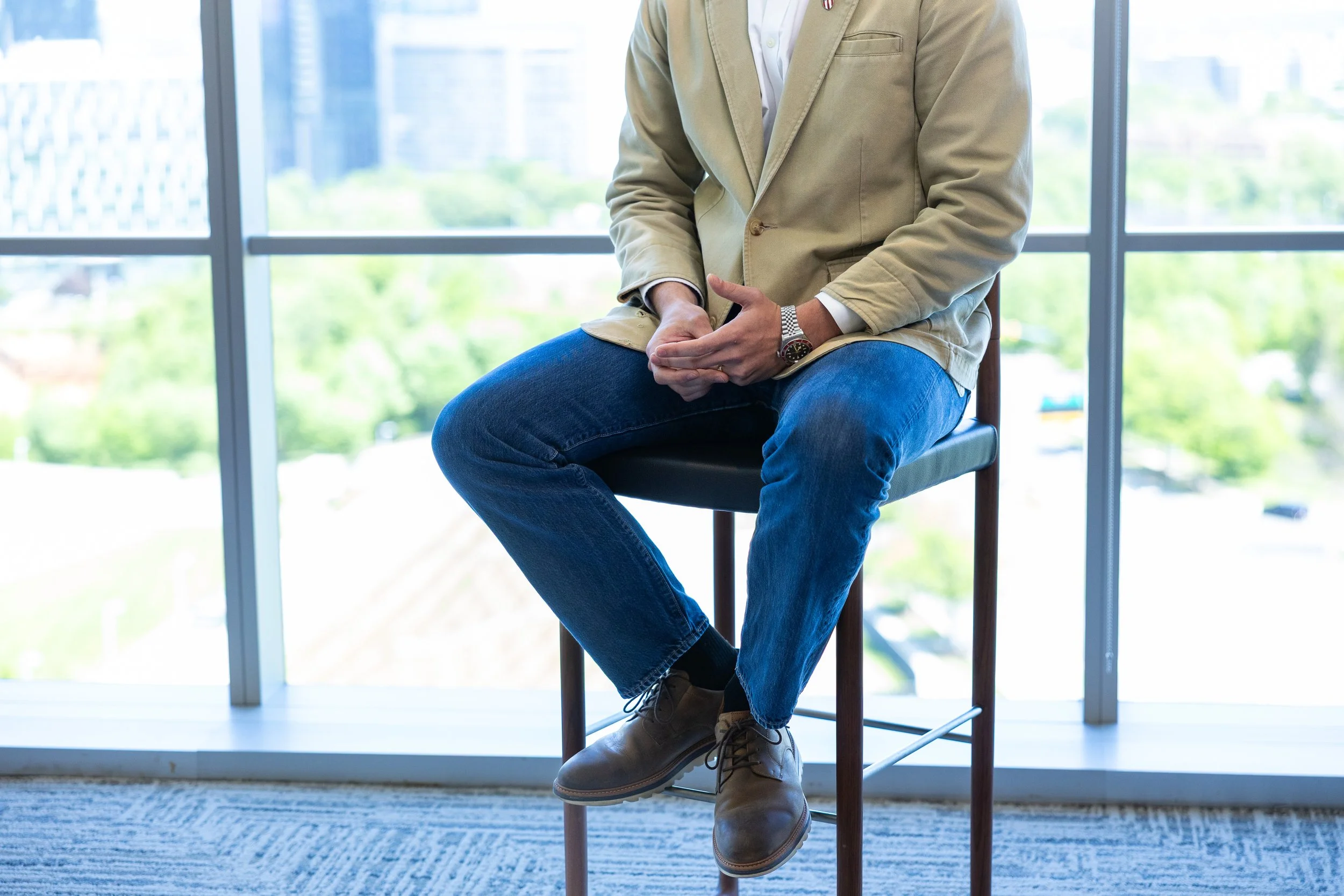 Male executive seated during corporate interview video shoot in Tysons Corner Virginia with blurred background