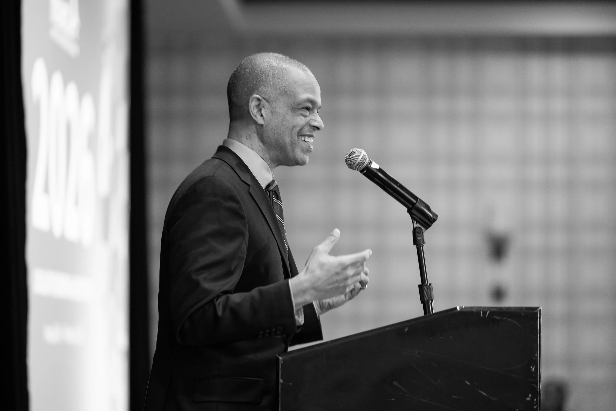 Keynote speaker presenting at podium during corporate event in Washington DC captured in black and white professional event photography