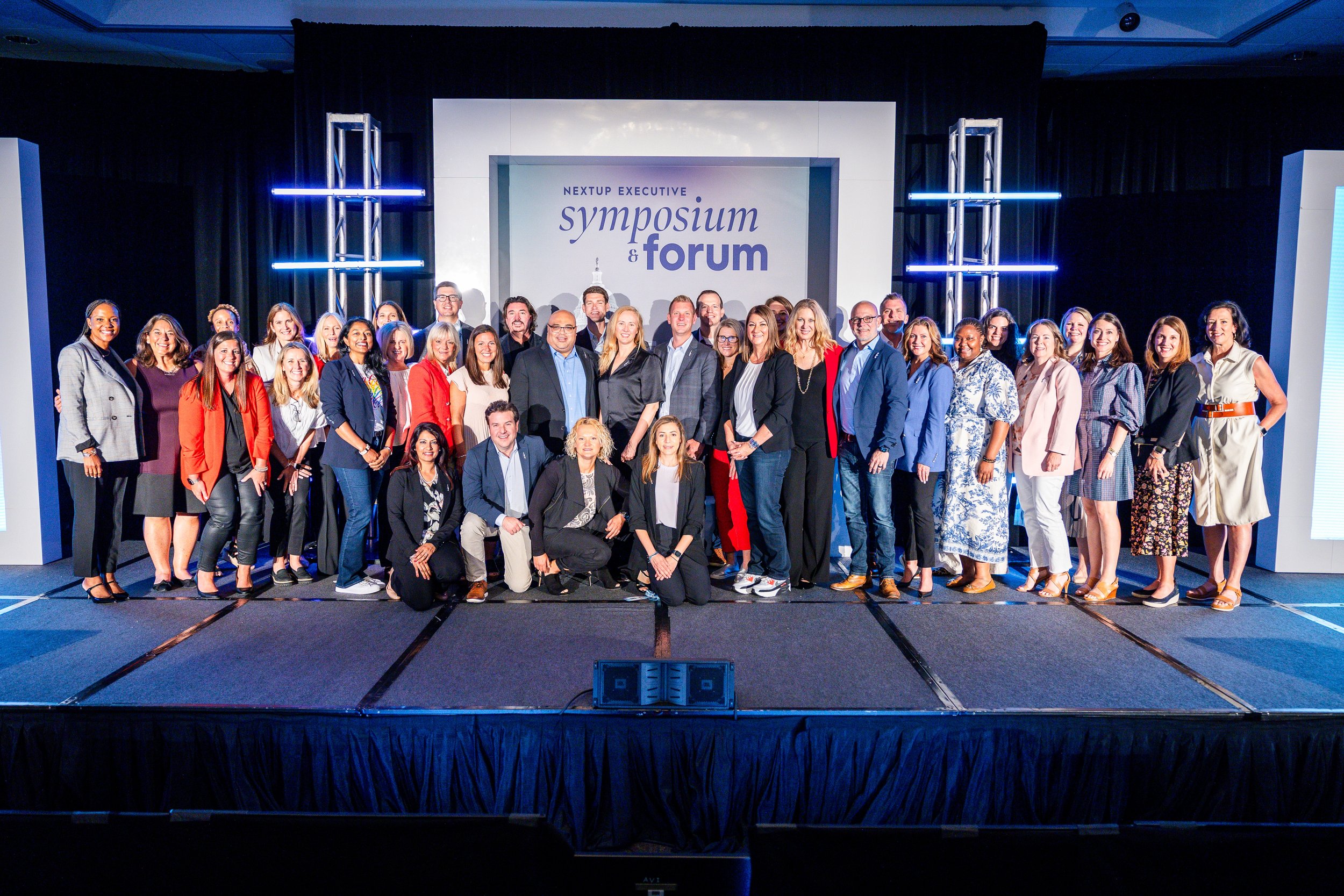Corporate conference group photo on stage at executive symposium and forum event
