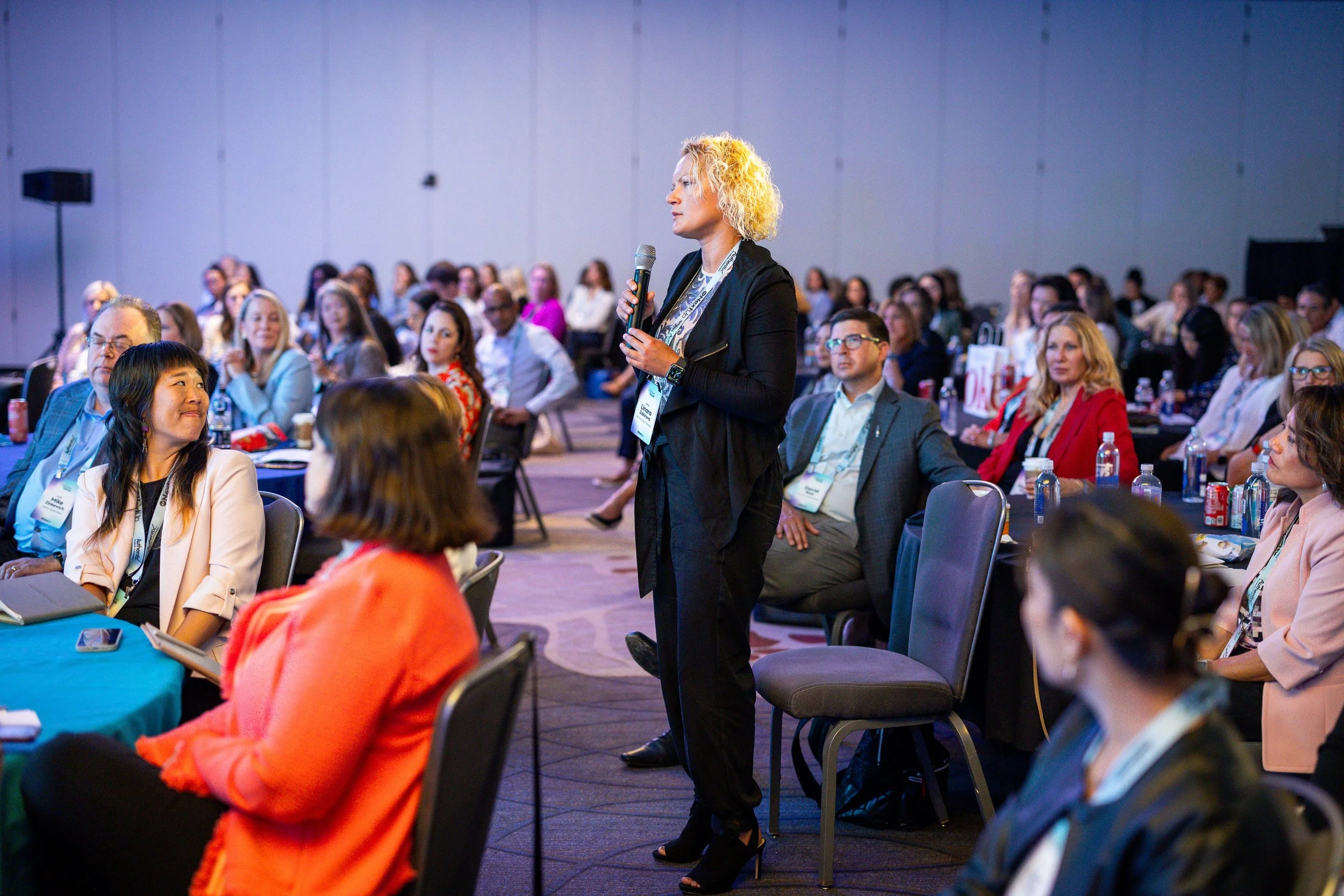 Audience member asking a question at a corporate conference in Washington DC, showcasing event engagement and professional event photography