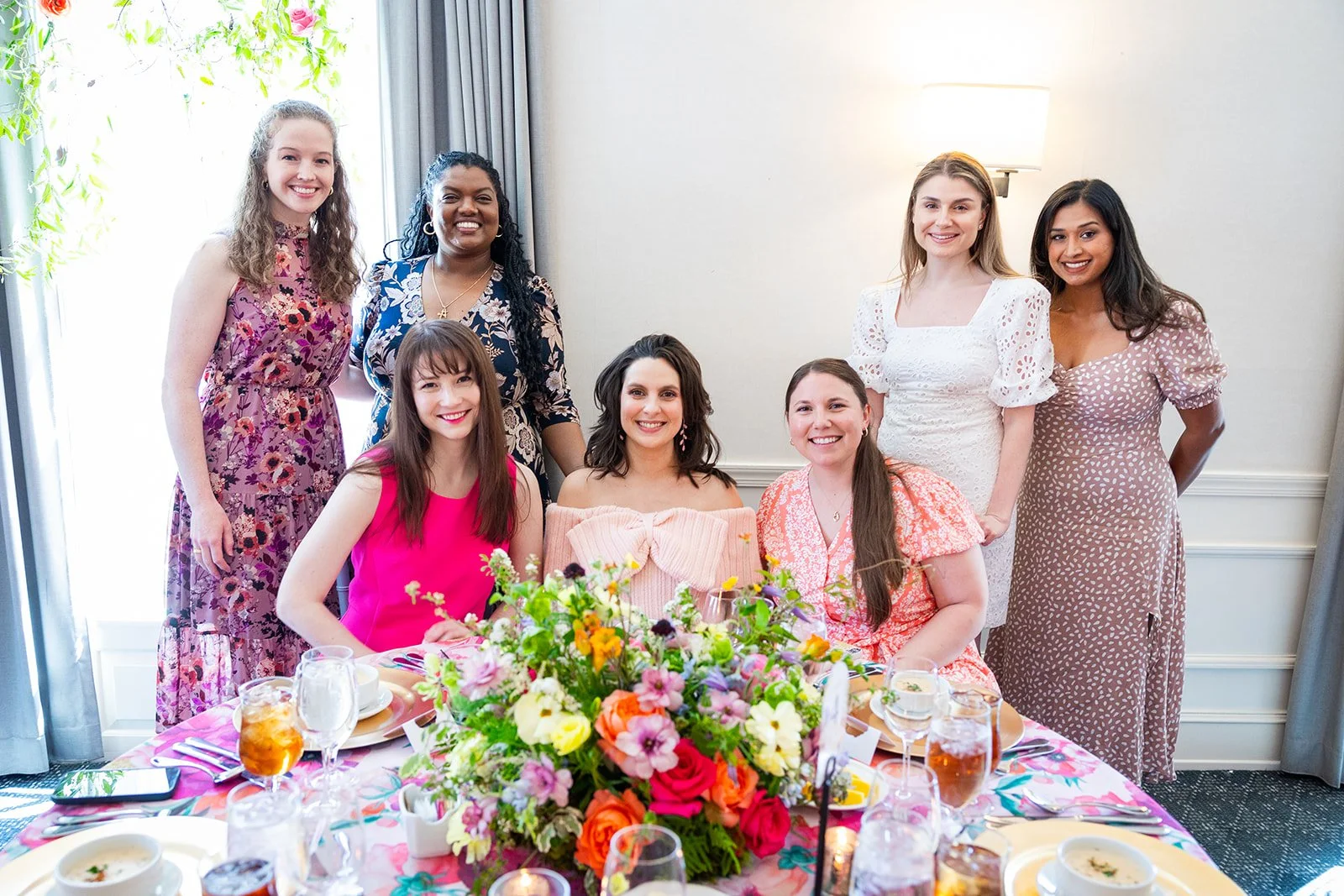 Group portrait of expectant mother and close friends at the head table during celebration event at Morrison House Alexandria