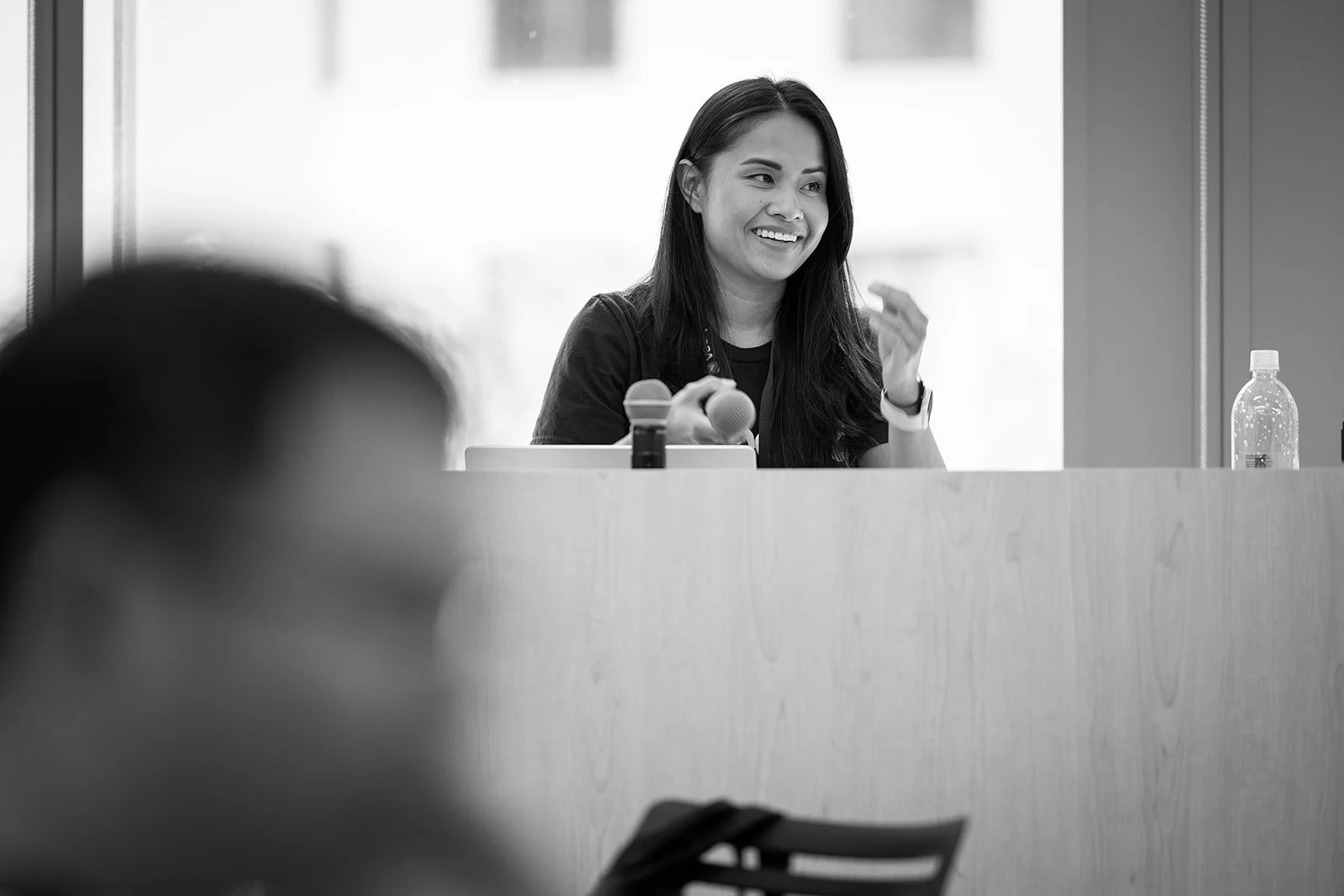 Black and white photo of corporate event speaker at podium presenting at AWS Jasper in Arlington Virginia