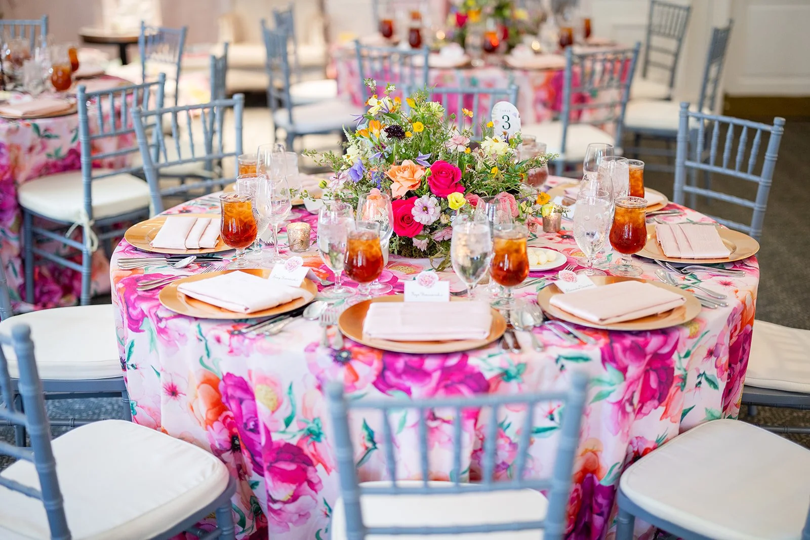 Vibrant mixed floral centerpiece and bold floral print tablecloth detail at Morrison House event in Old Town Alexandria