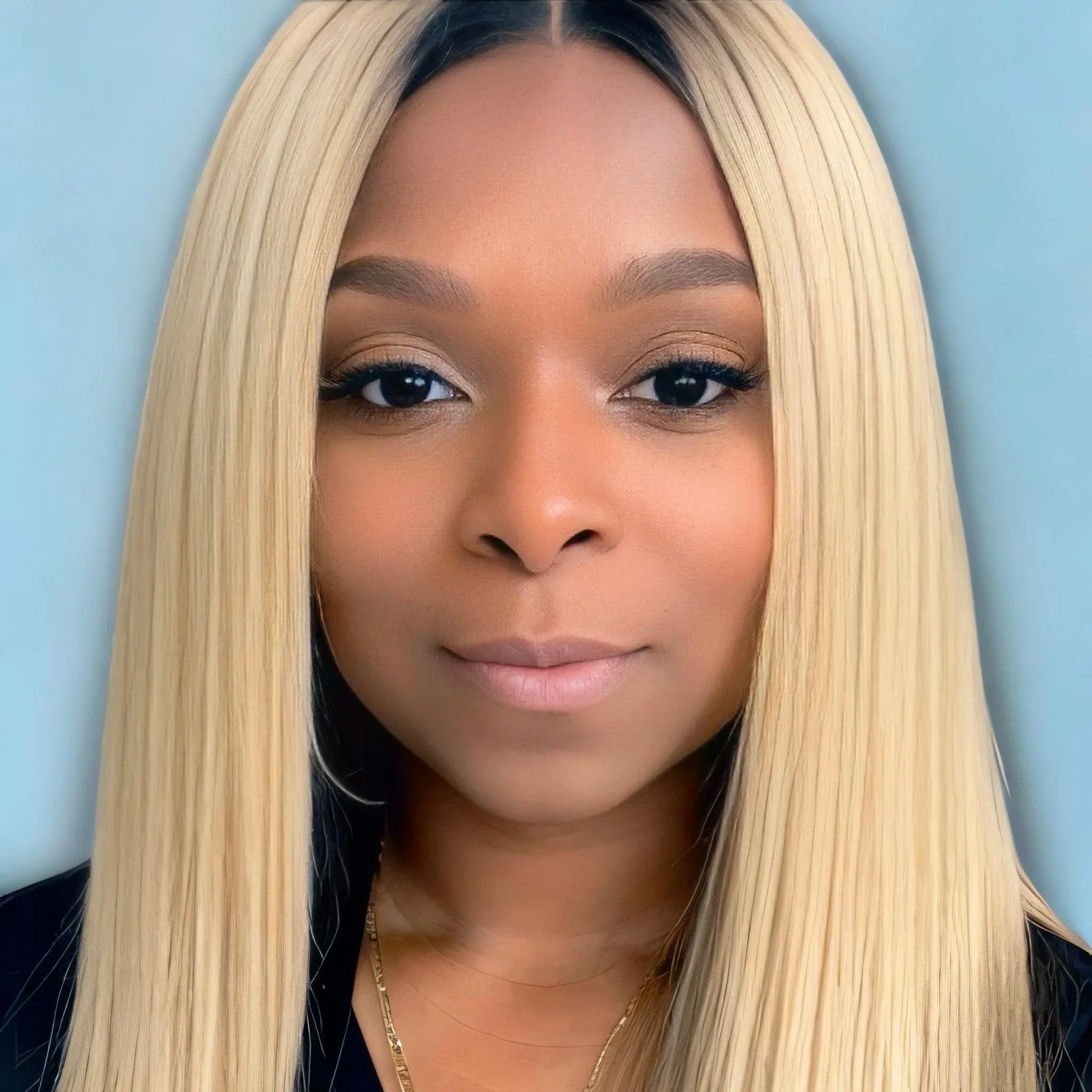 Close-up portrait of a woman with long, straight blonde hair, wearing natural makeup and a black top, against a light blue background.