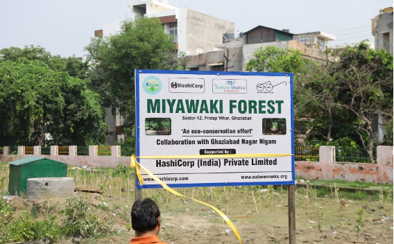 A signboard for Miyawaki Forest in Ghaziabad, India, sponsored by HashiCorp (India) Private Limited, featuring logos and information about eco-conservation efforts.
