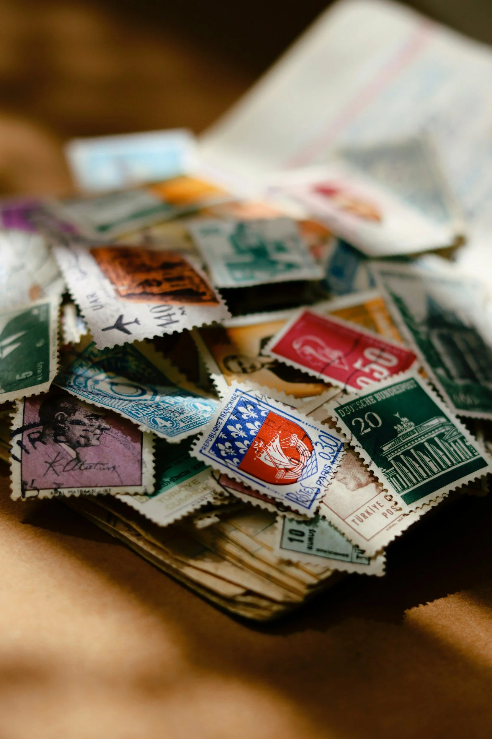 A pile of colorful international postage stamps scattered on a surface.