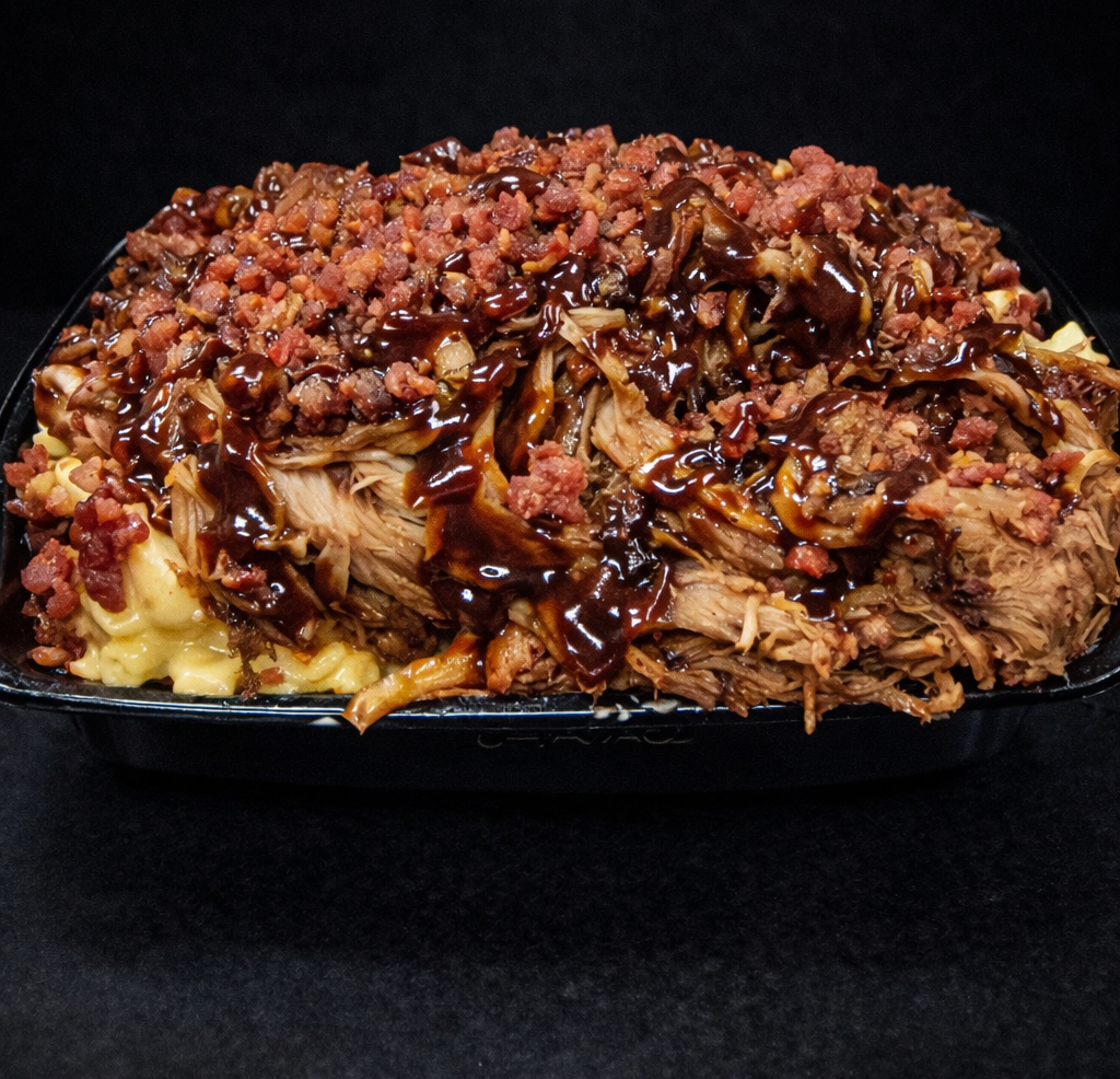 Barbecue pulled pork sandwich with bacon bits and barbecue sauce