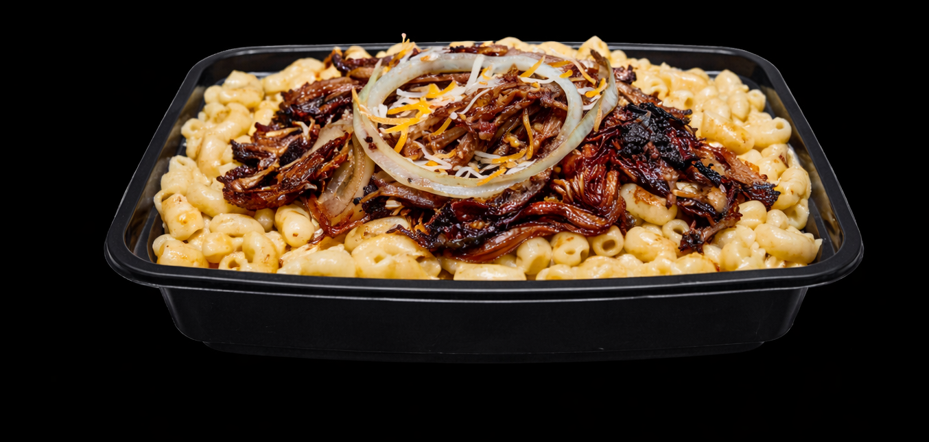 A black tray of creamy macaroni and cheese topped with shredded cheese, caramelized onions, and shredded beef.