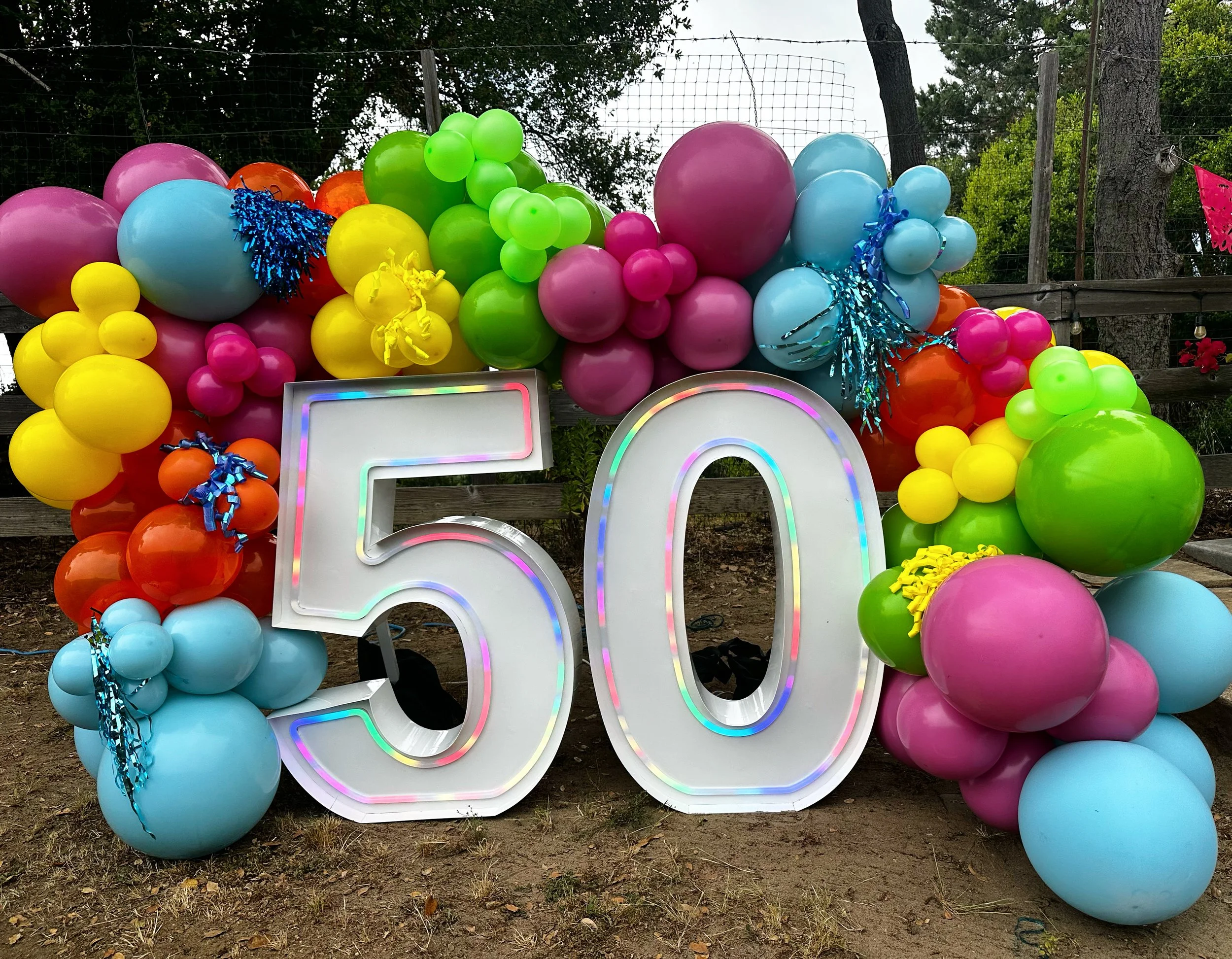 Colorful balloon display with large illuminated '50' sign for a celebration or birthday party.