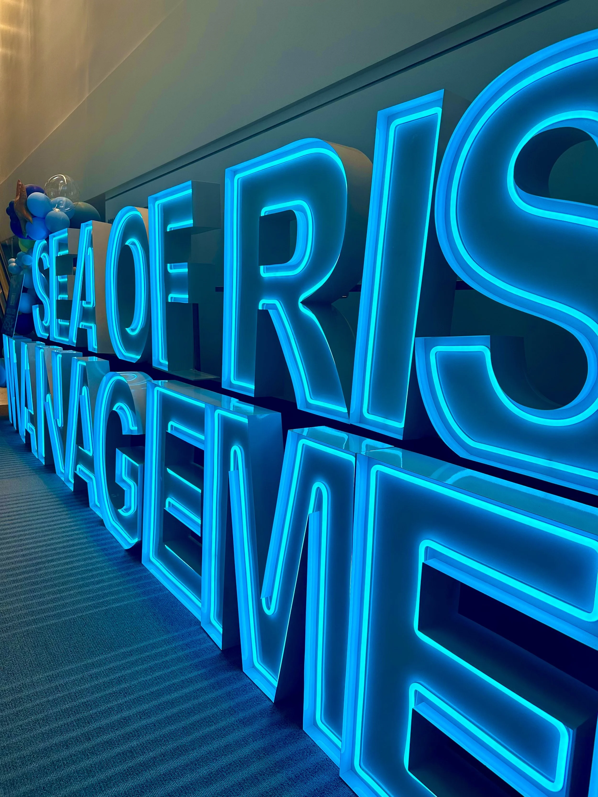 Bright blue neon sign spelling 'SEAFOOD' and 'RECEPTION' on a wall.